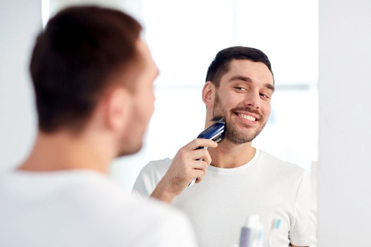 Happy man grooming his beard