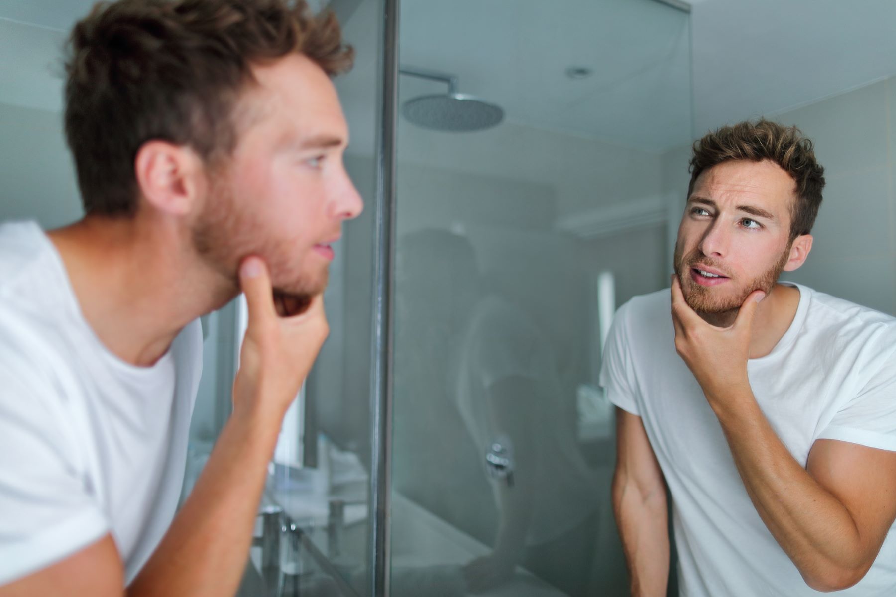 Man carefully inspecting his beard for beard hair loss