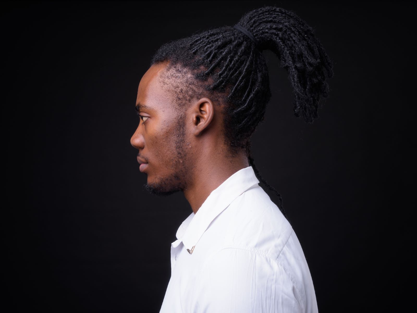 Man with tied up dreadlocks and a receding hairline