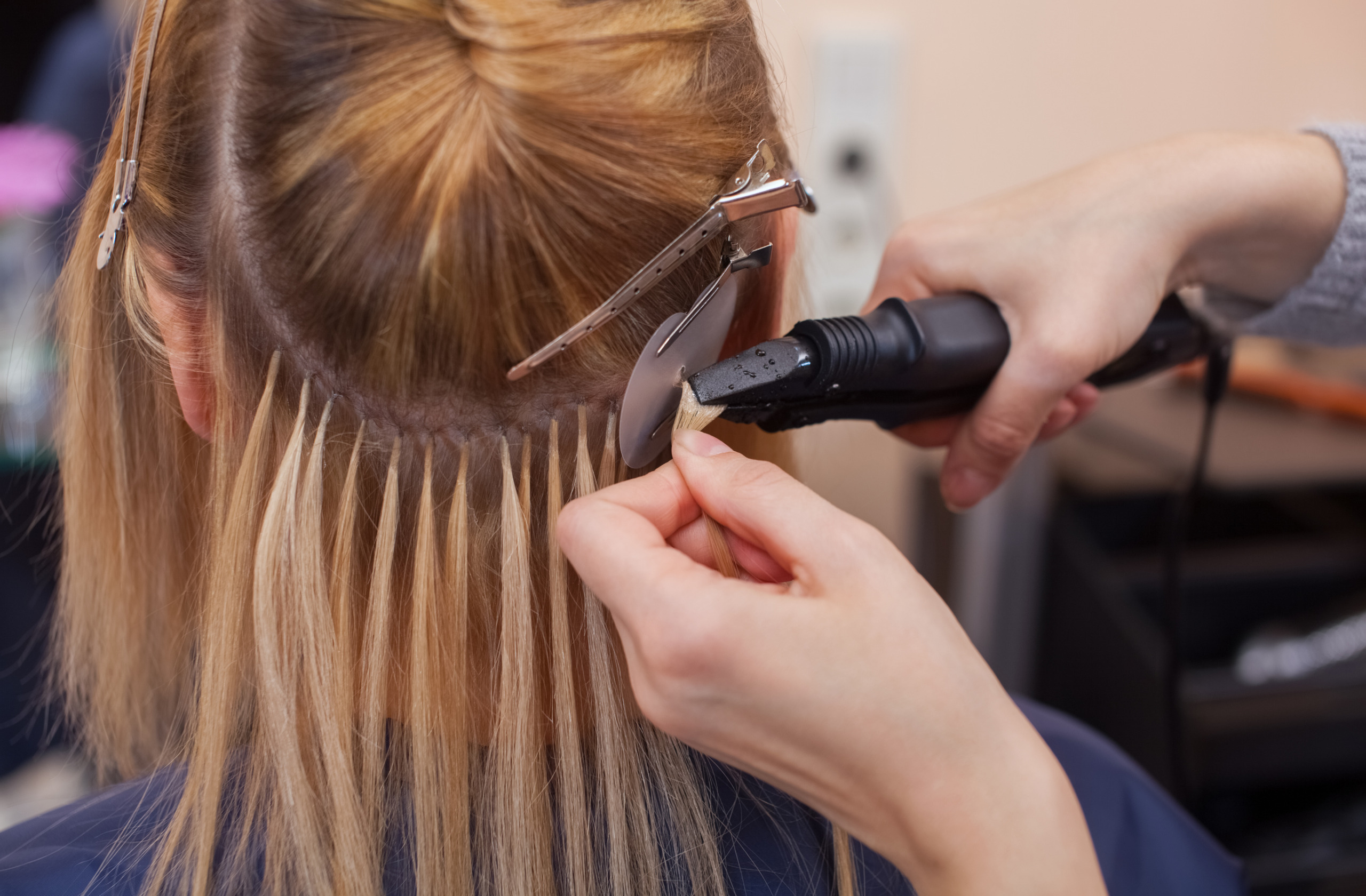 permanent hair extensions being applied by a professional