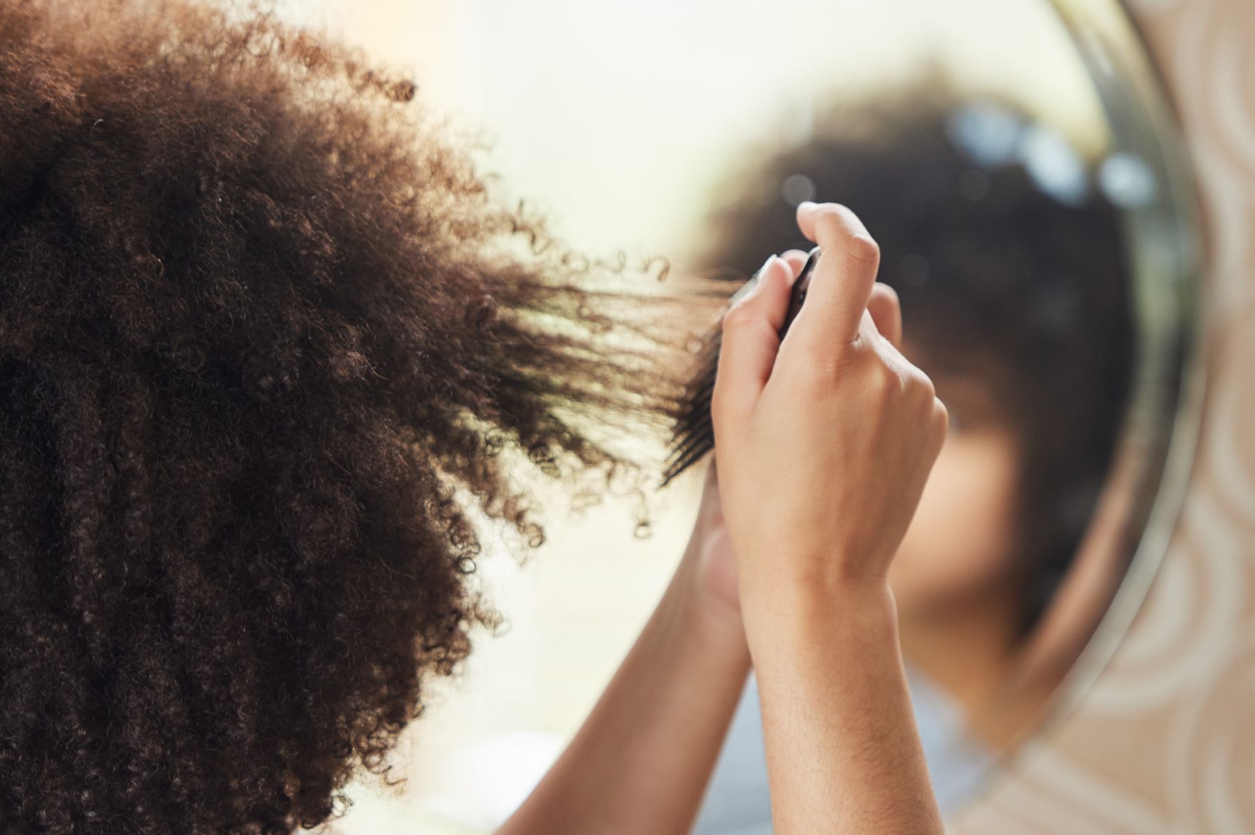 woman combing afro hair