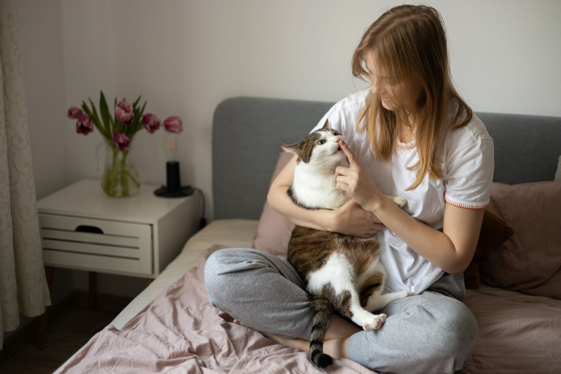 Woman not allowing cat to lick her