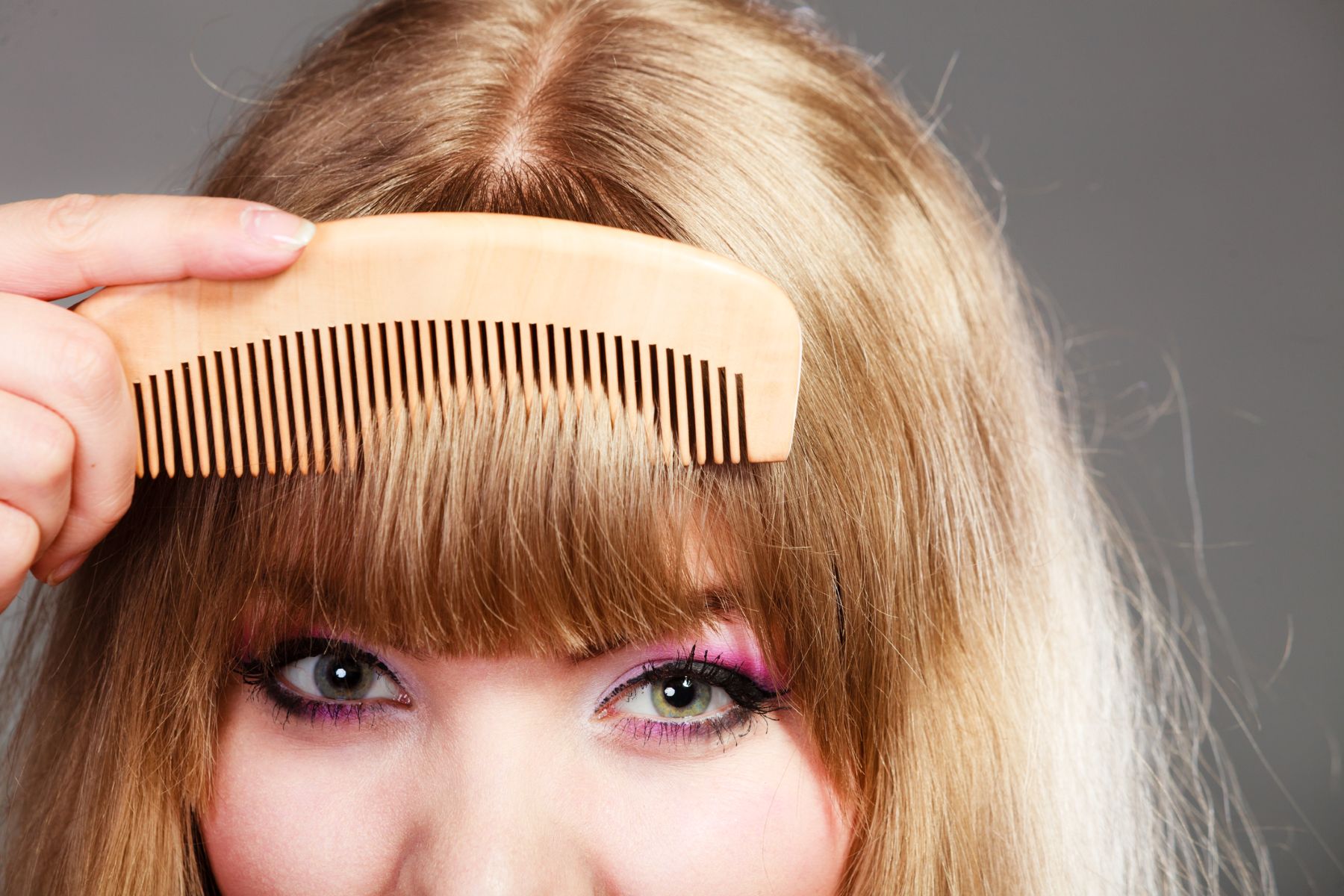 Woman trying to make her fringe appear fuller