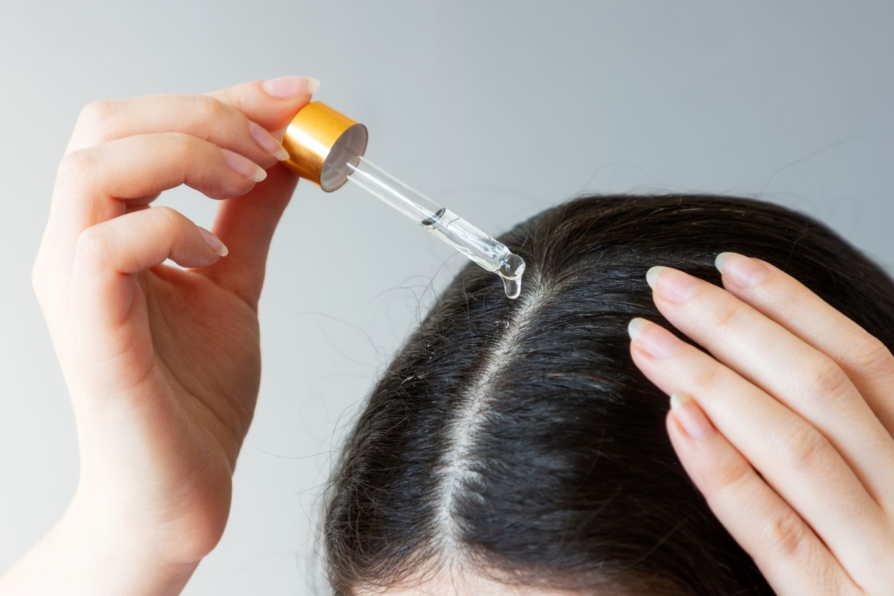 Woman applying treatment to dry hair