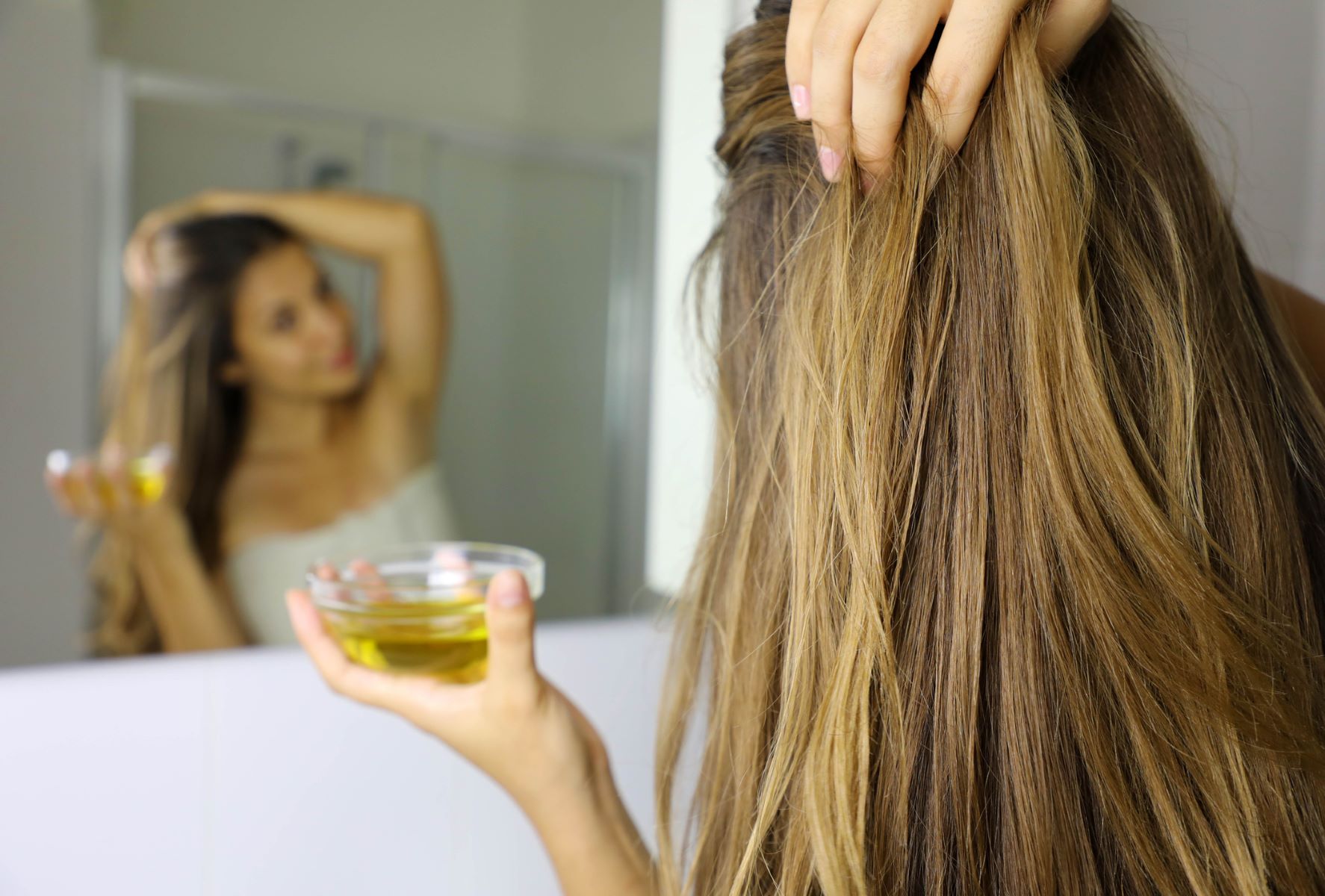 Woman using a good type of olive oil on her hair