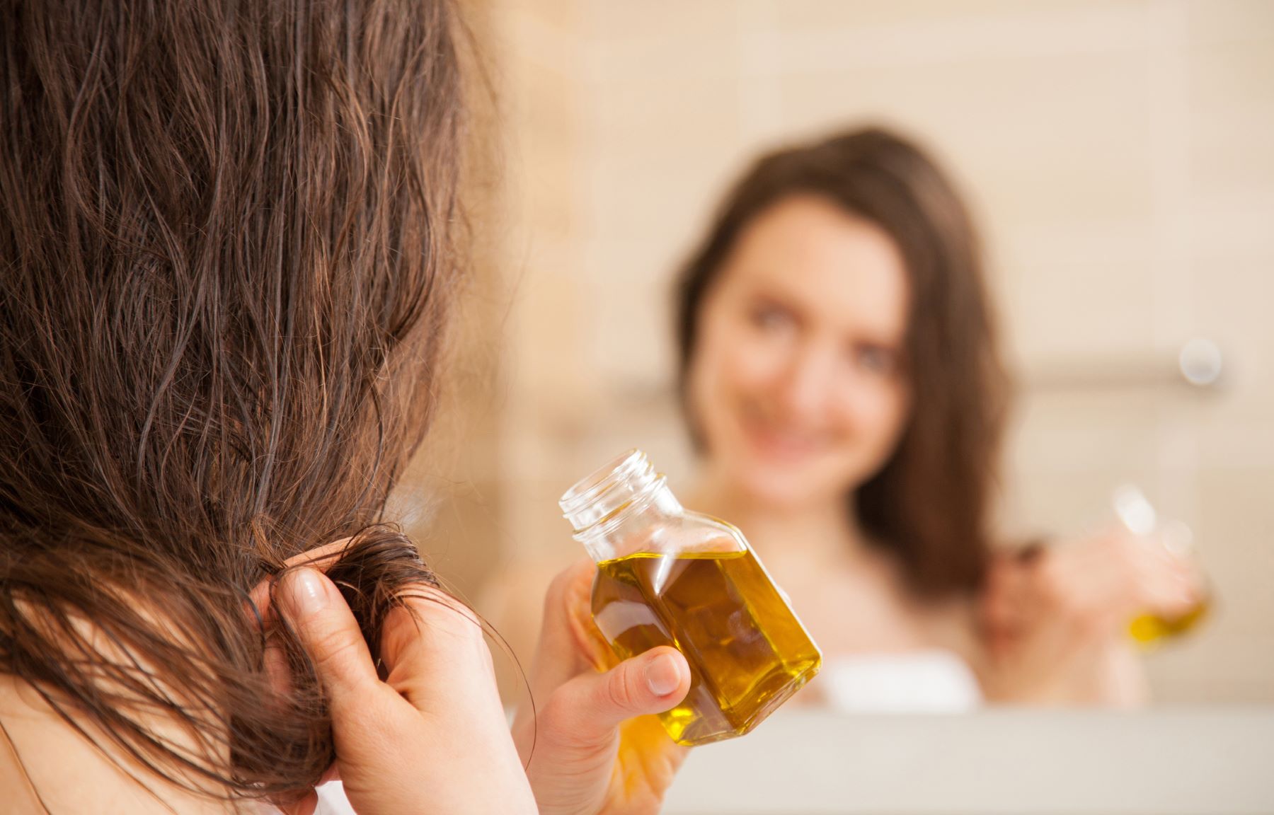 Woman using olive oil for her hair