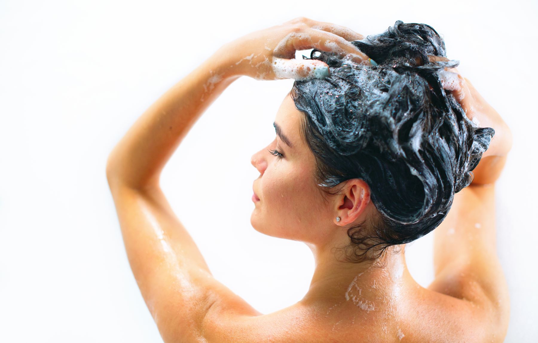 person massaging a small amount of shampoo into wet hair