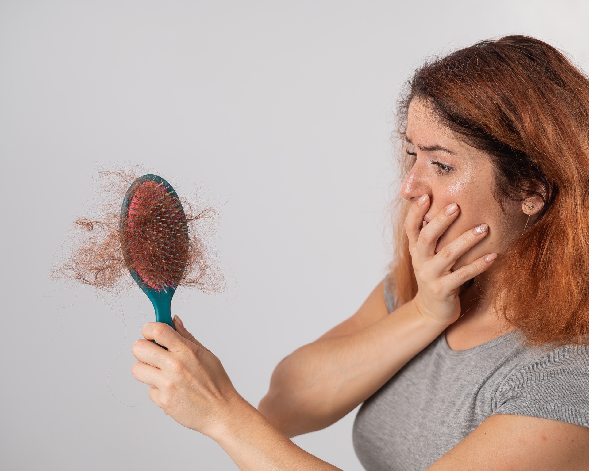 woman horrified by the amount of hair on brush