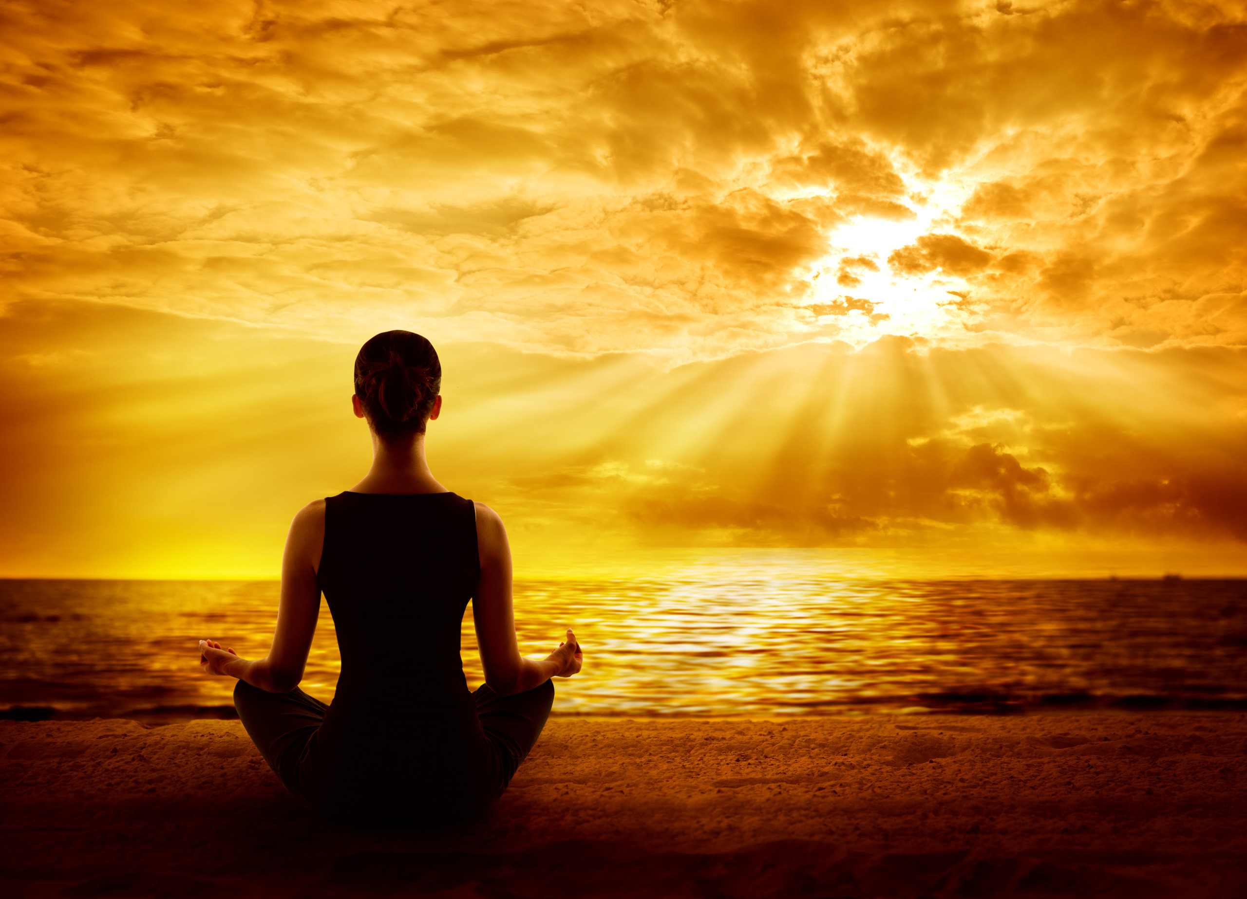 person meditating to sunrise