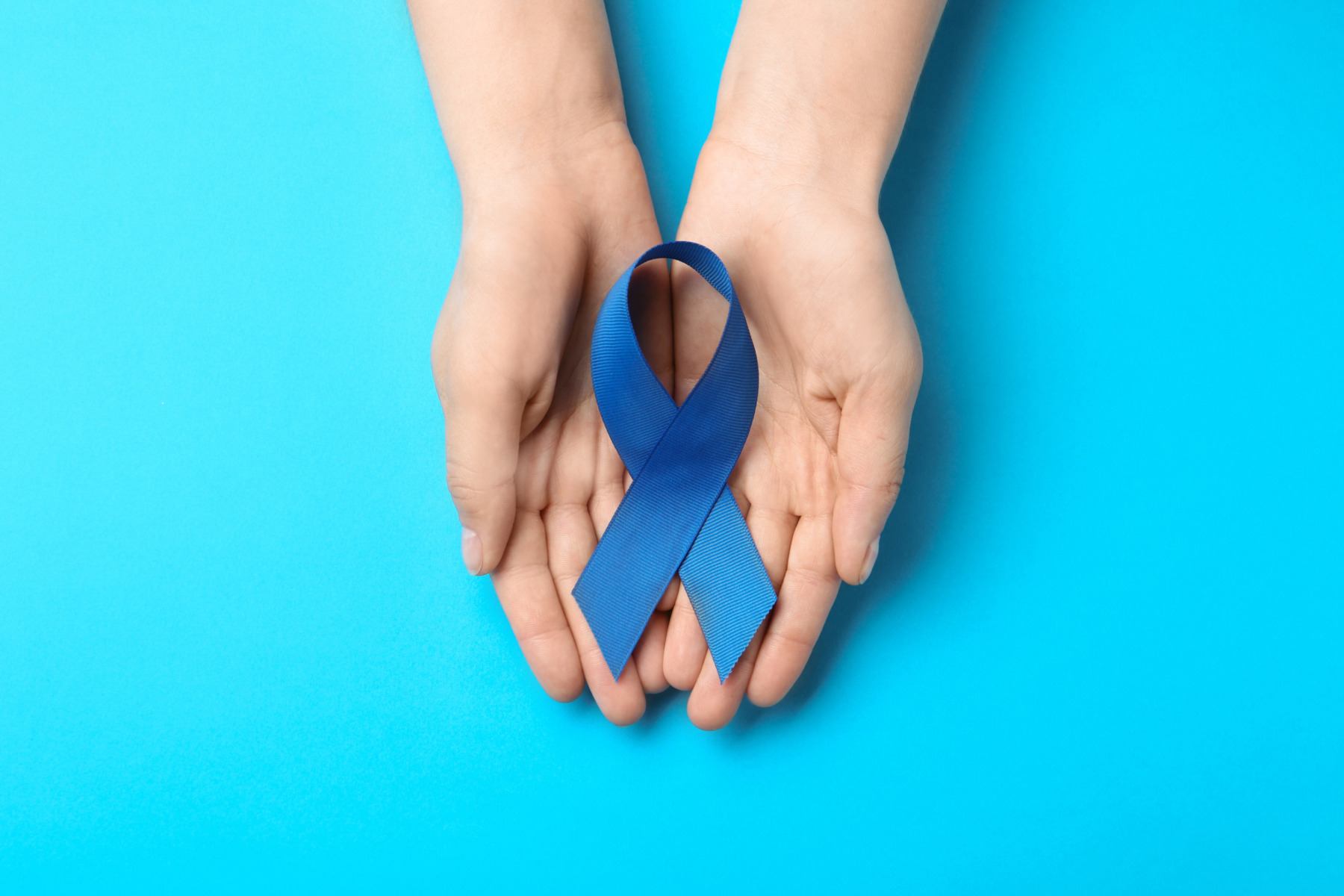 person holding a blue awareness ribbon