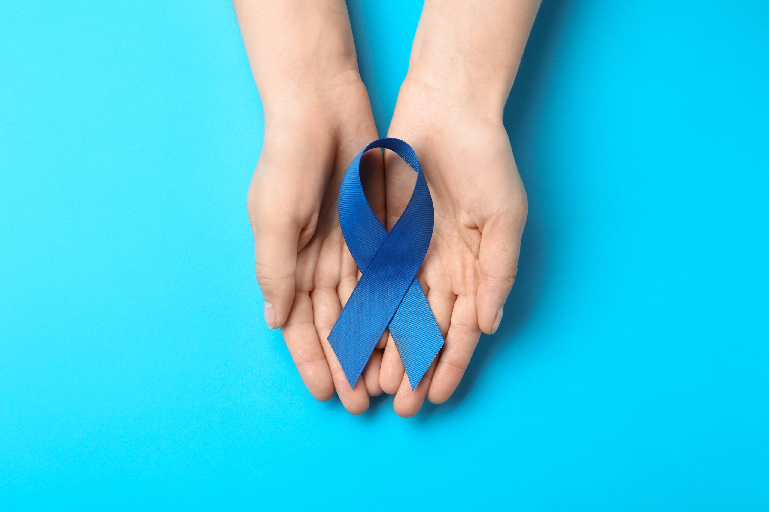 person holding a blue awareness ribbon