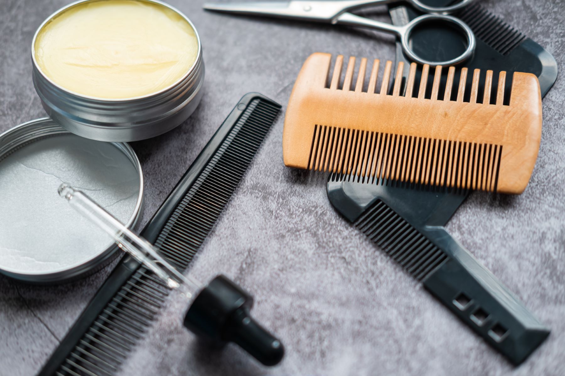 Beard grooming supplies (combs, scissors, beard balm and beard oil dropper)