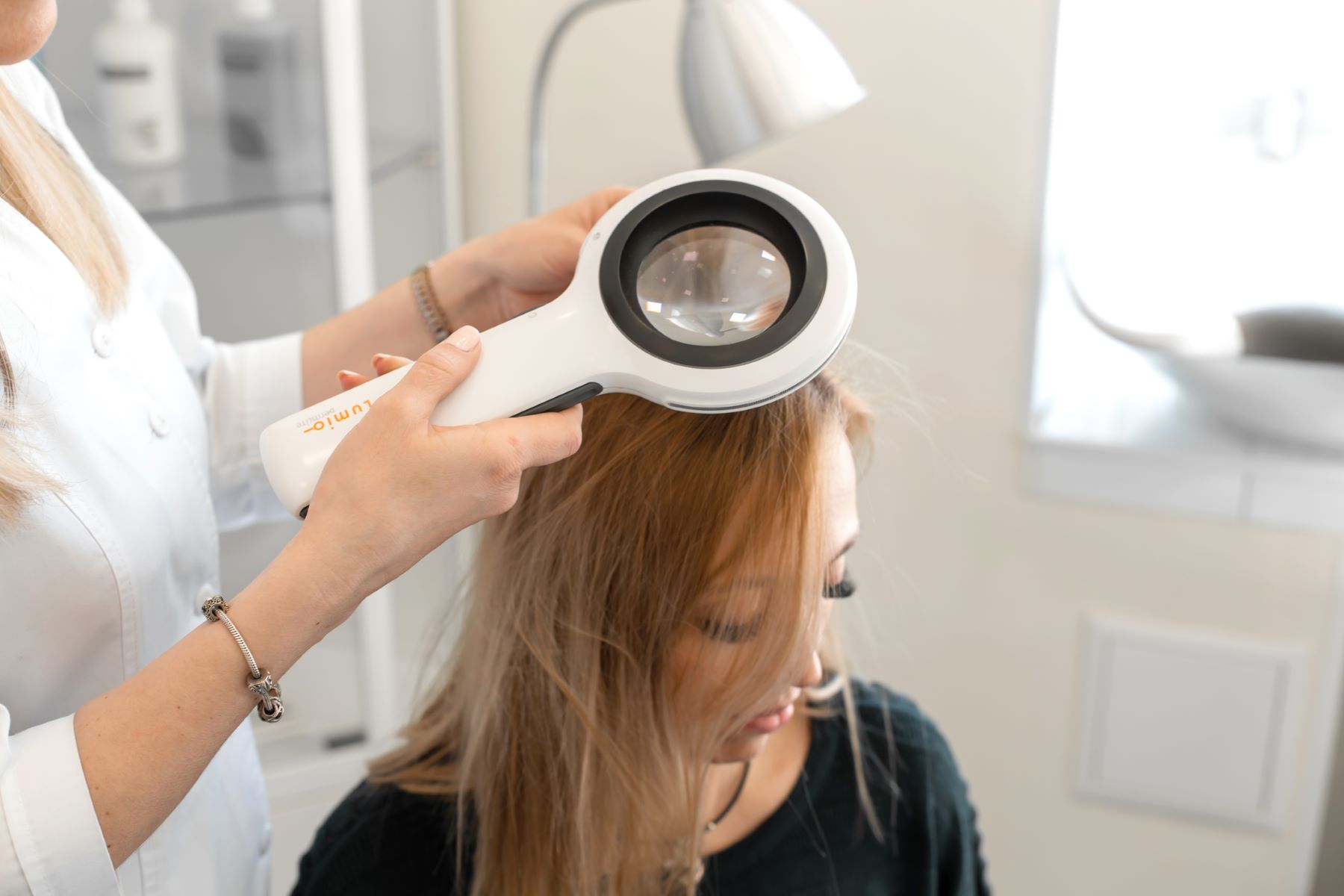 Doctor diagnosing hair loss in a female patient