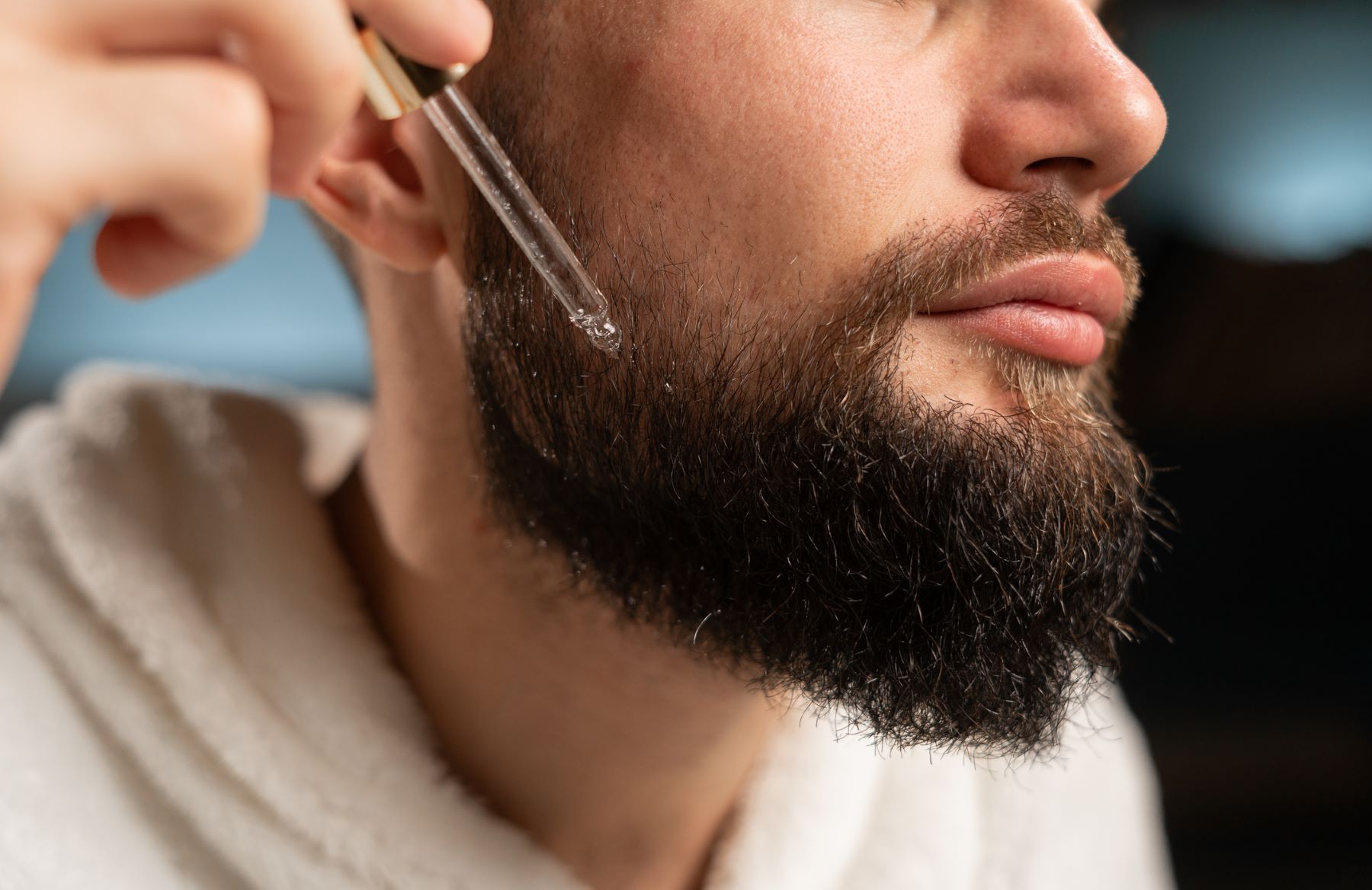 Man applying oil to his beard