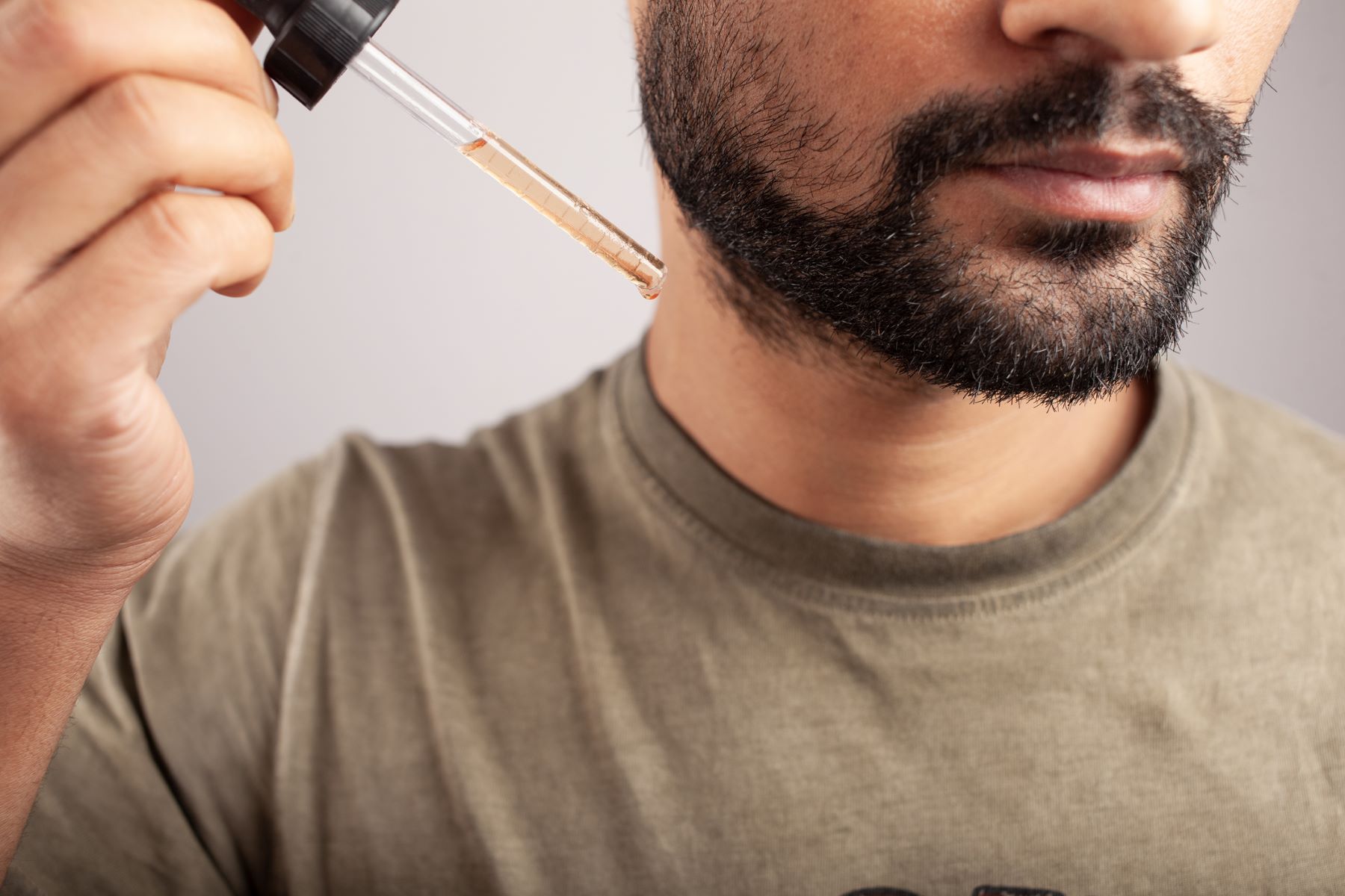 Man applying topical Minoxidil to his beard