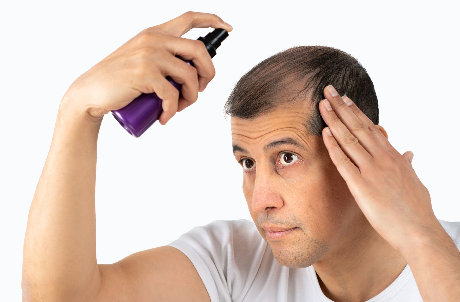Man balding on top using hair thickening spray
