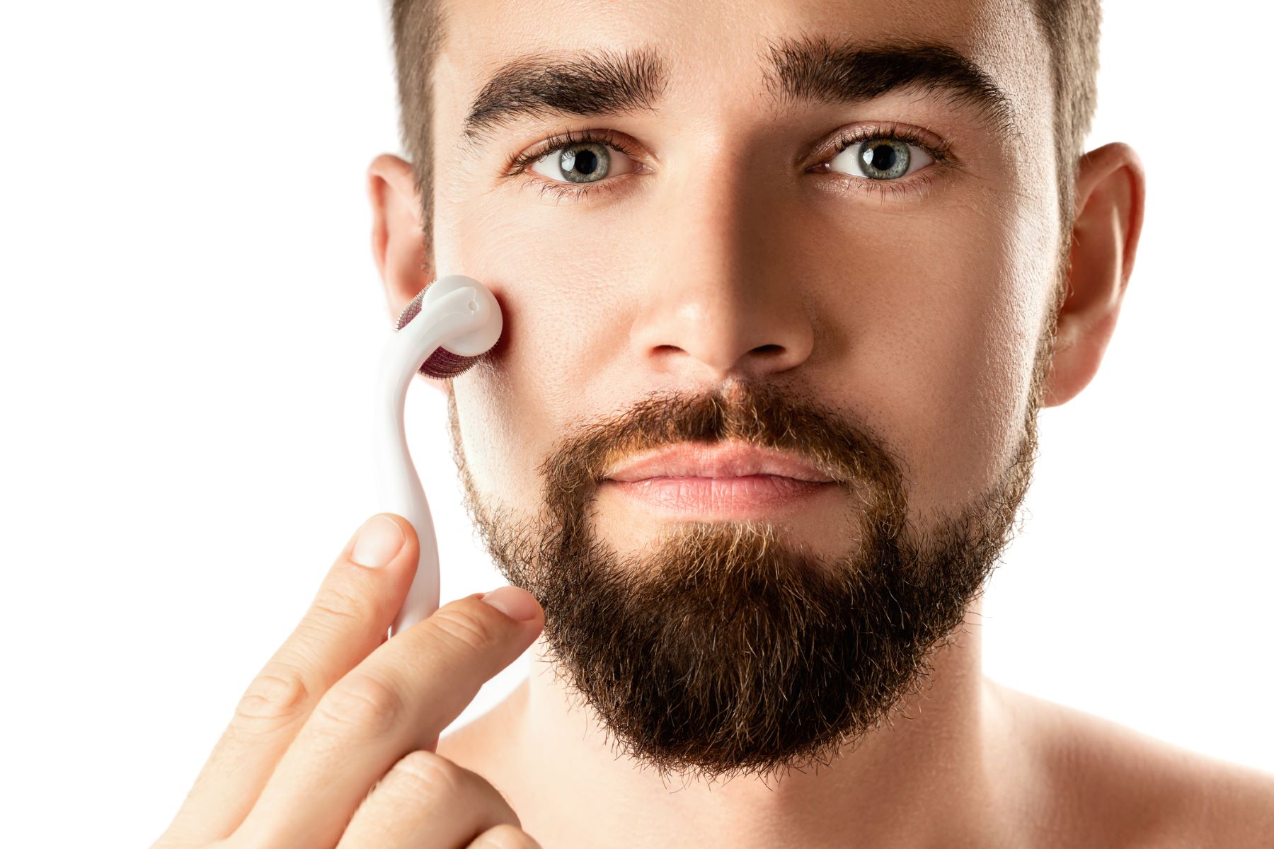 Man using a beard roller on his cheek
