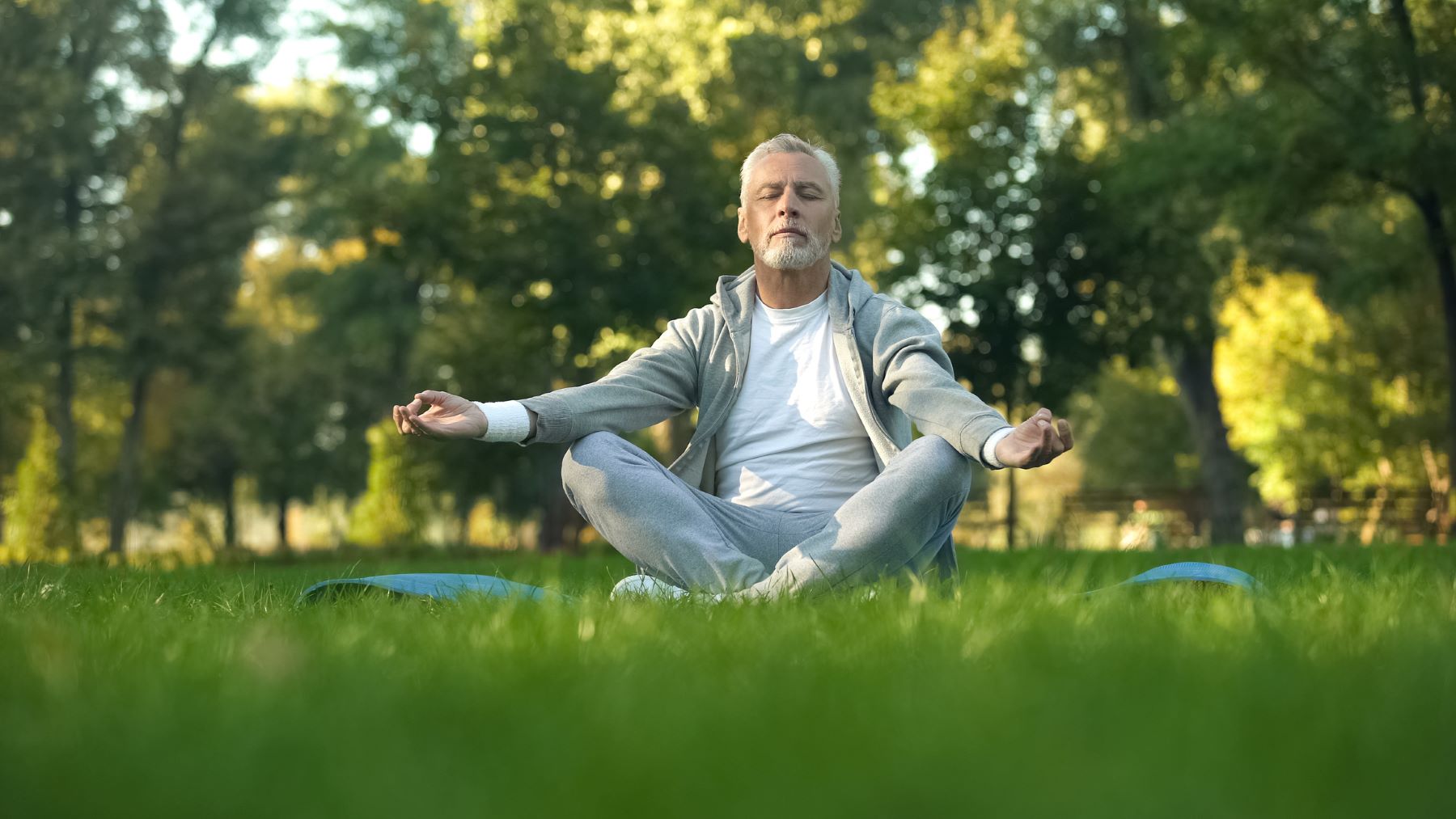 Middle aged man meditating outdoors