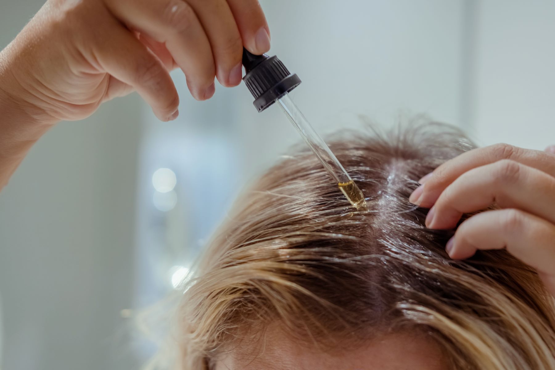 Woman applying Minoxidil to scalp