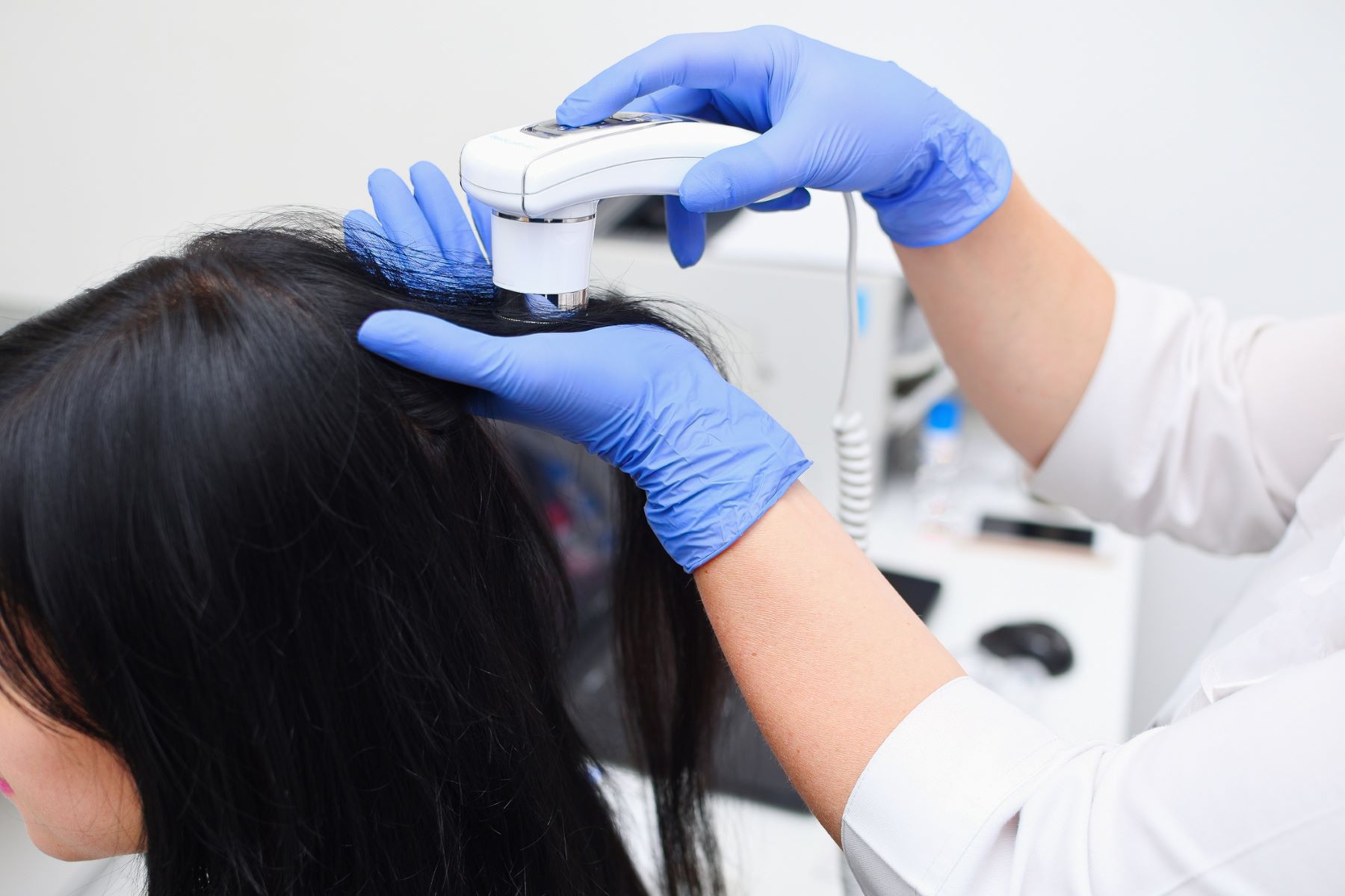 Woman getting hair restoration help from trichologist