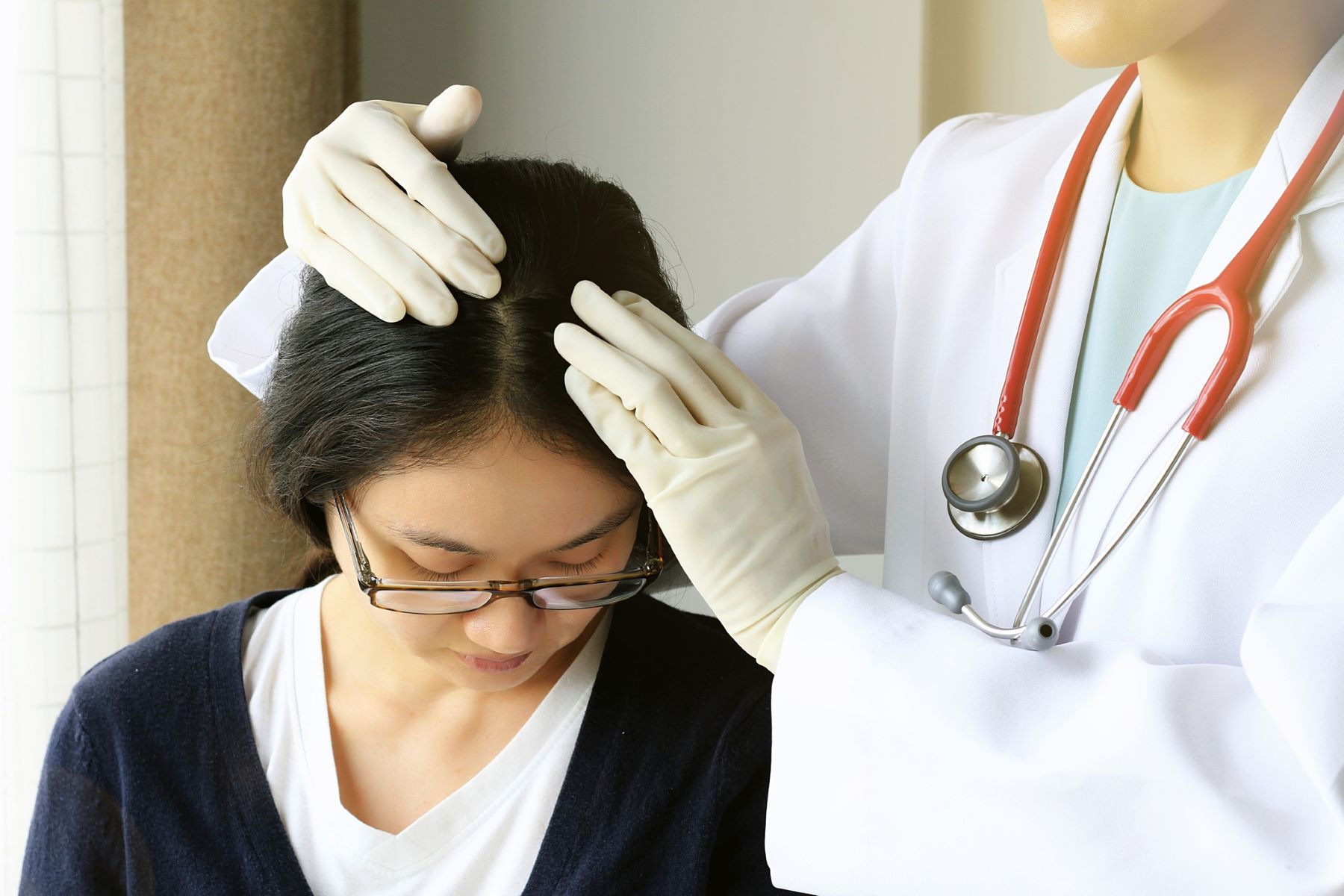 Woman undergoing hair scalp consultation with dermatologist