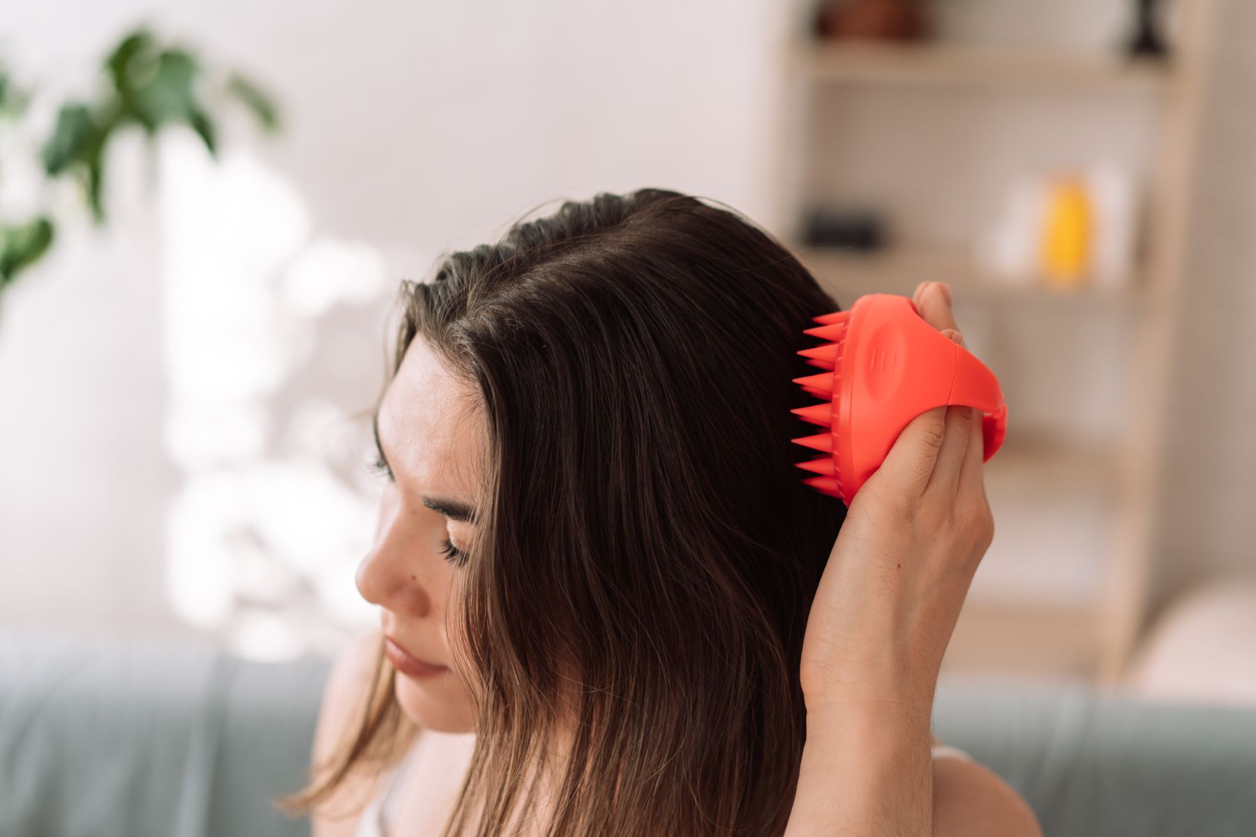 Woman giving herself a head massage at home