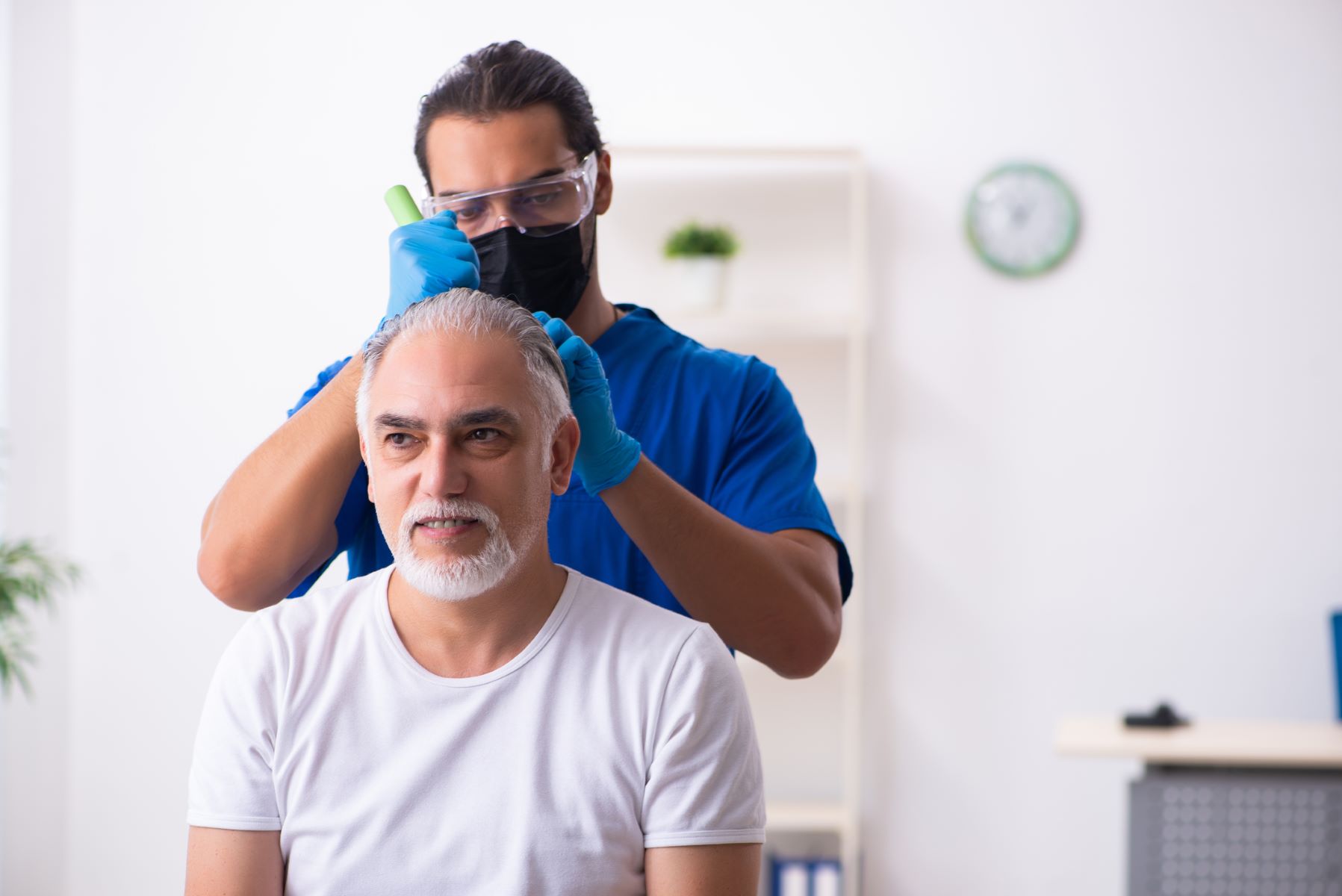 Hair transplant surgeon assessing patient