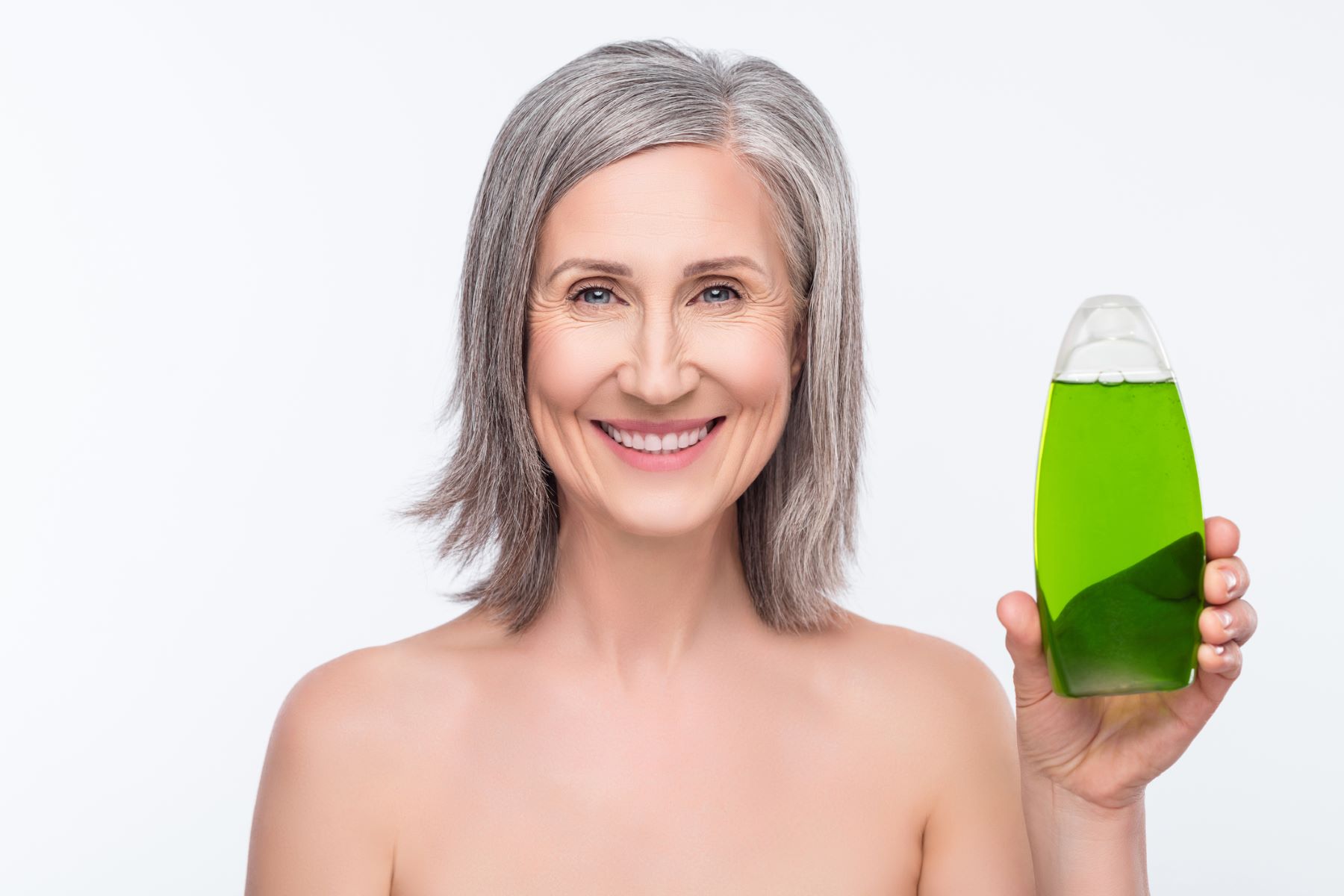 Woman with grey hair choosing a haircare product