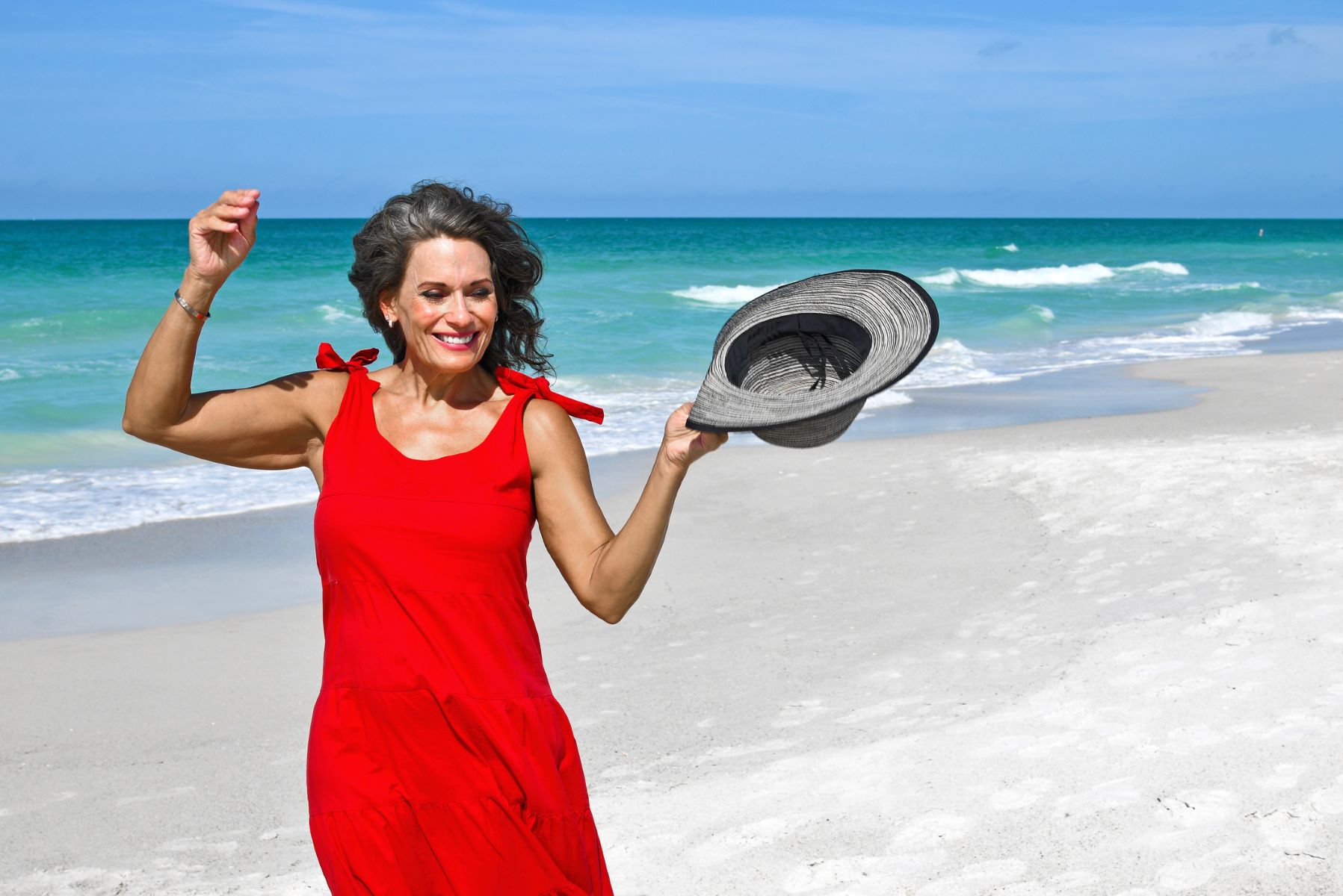 woman holding a hat in sunlight