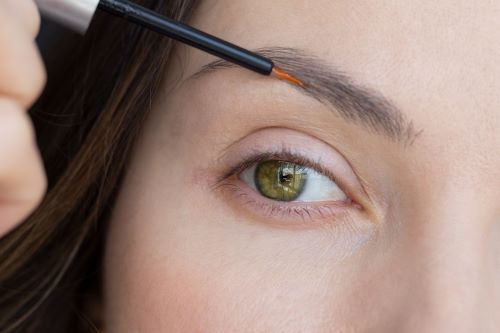 Woman applying Minoxidil to her eyebrows.