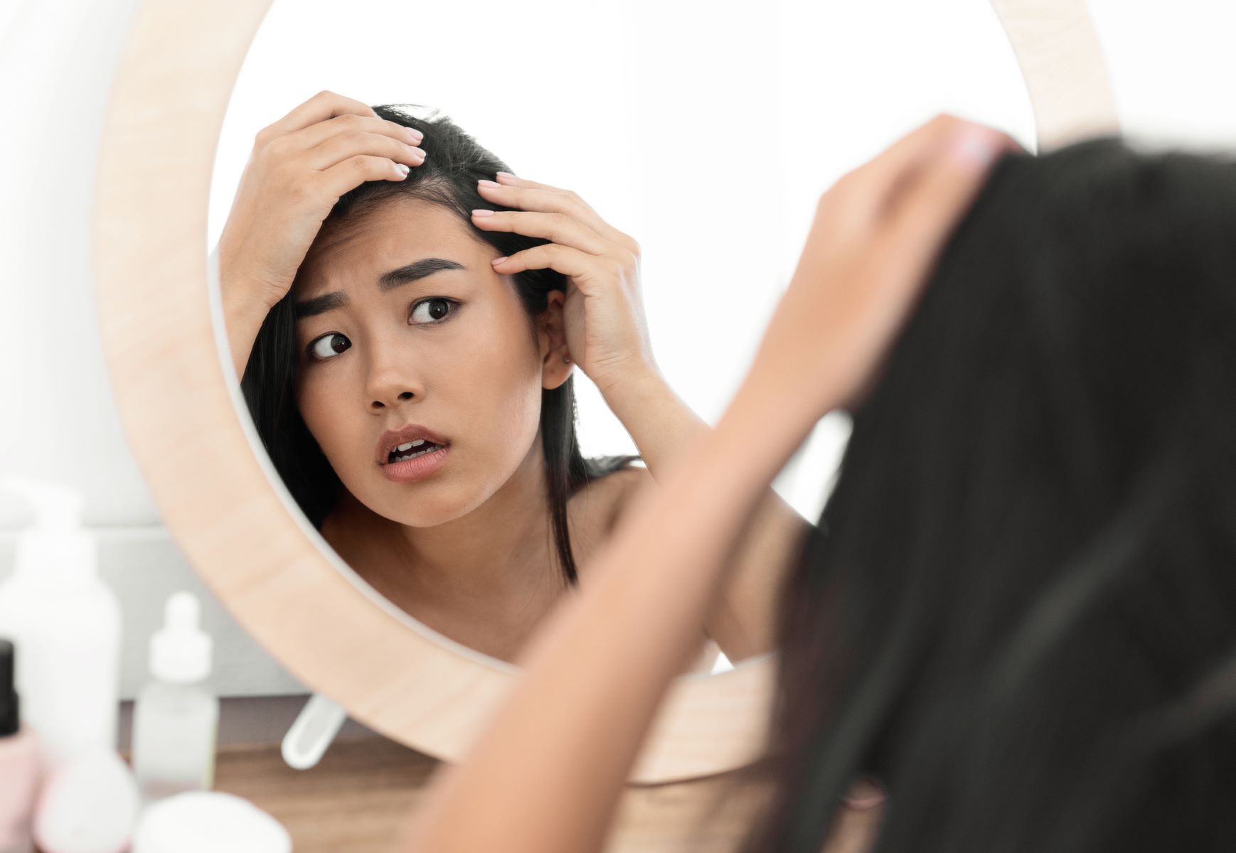 Woman checking her dry hair for thinning