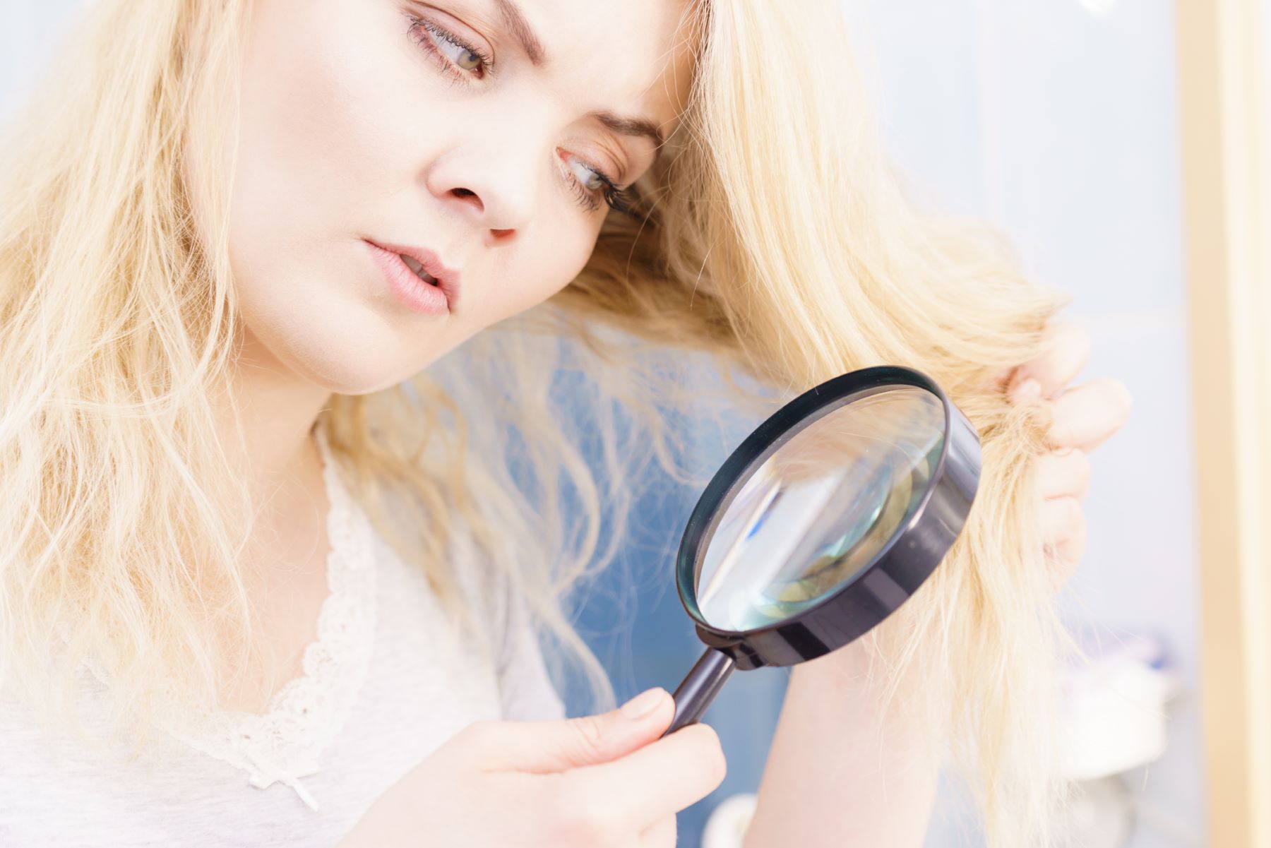 Woman looking for signs that her hair is damaged