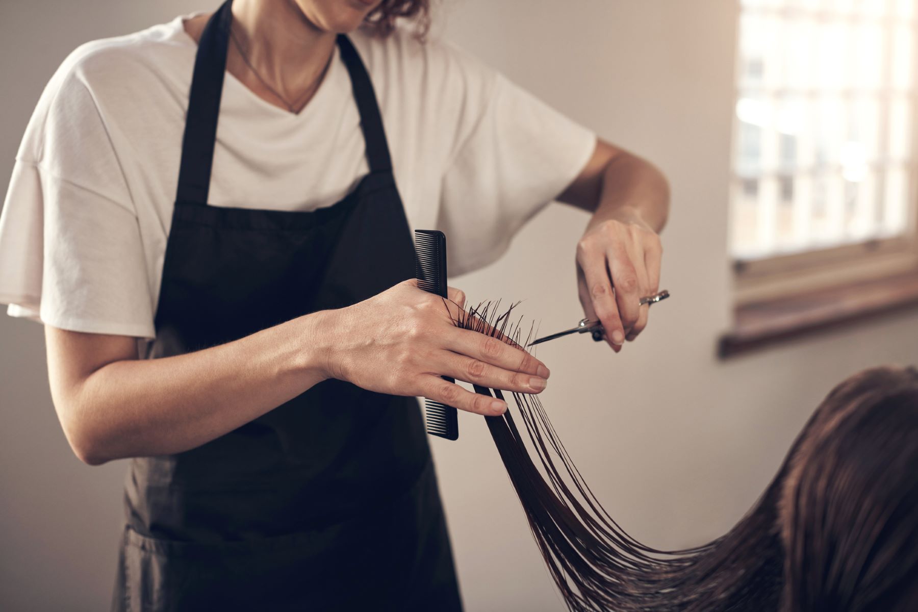 hair stylist trimming client’s ends