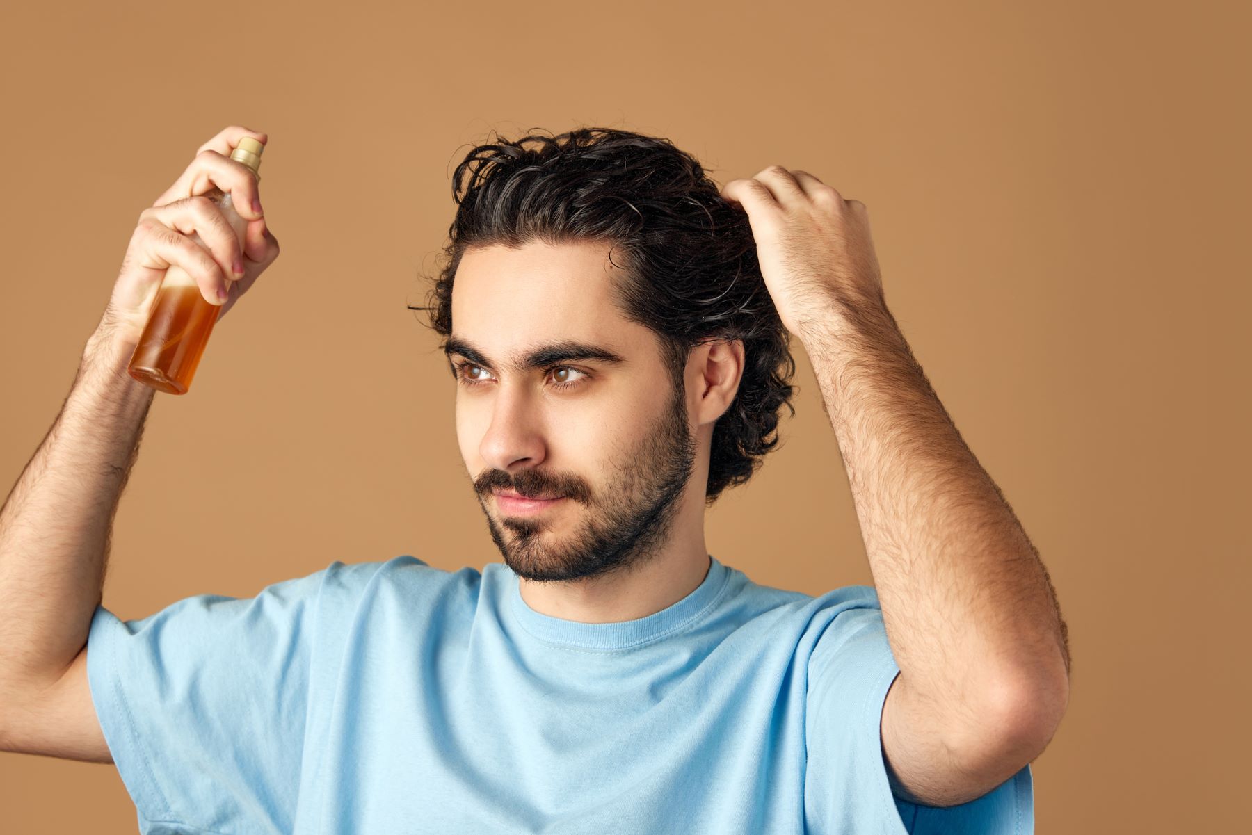 Man applying essential oils to his hair to reduce balding