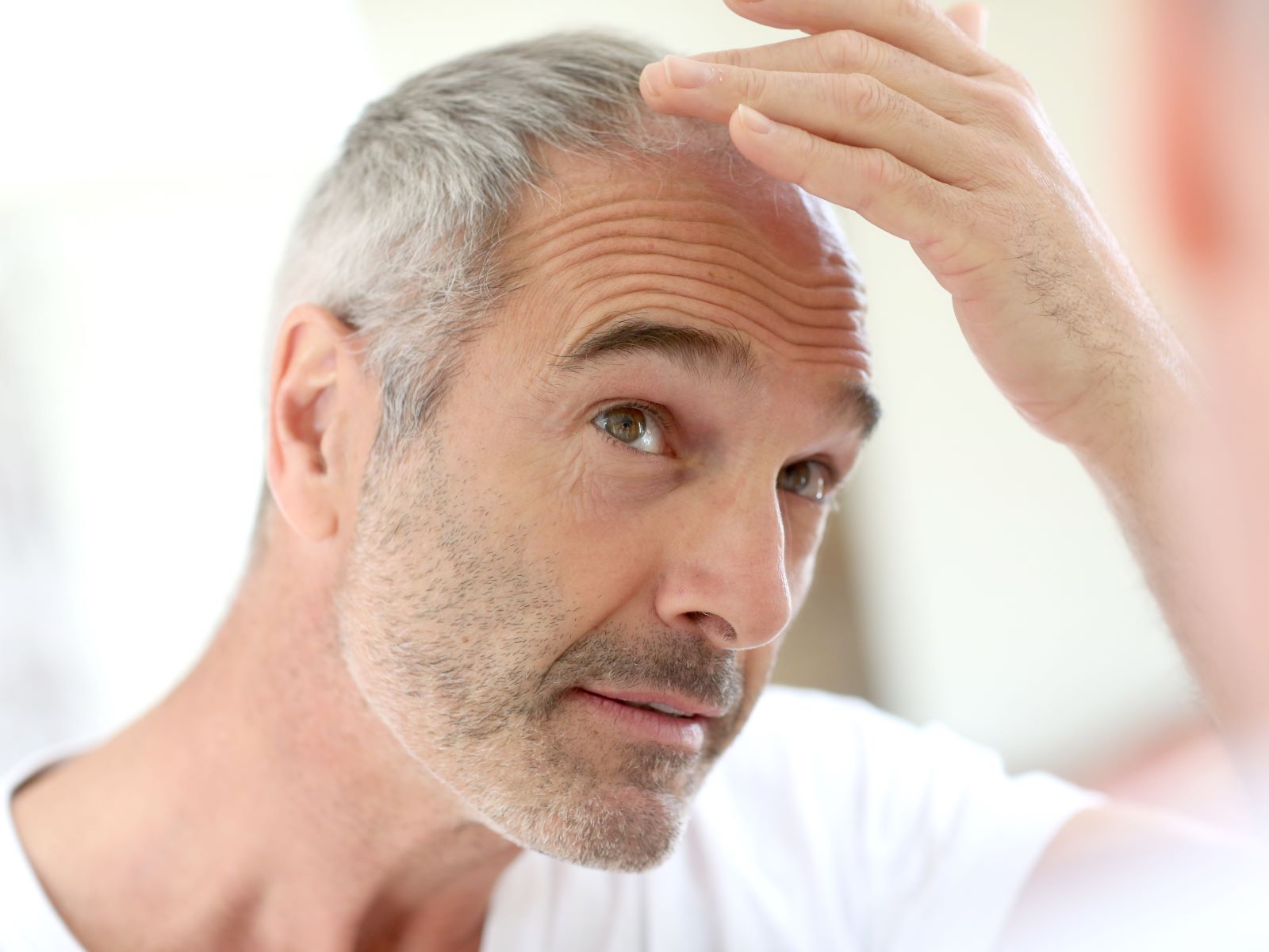 Man checking his scalp for hair loss