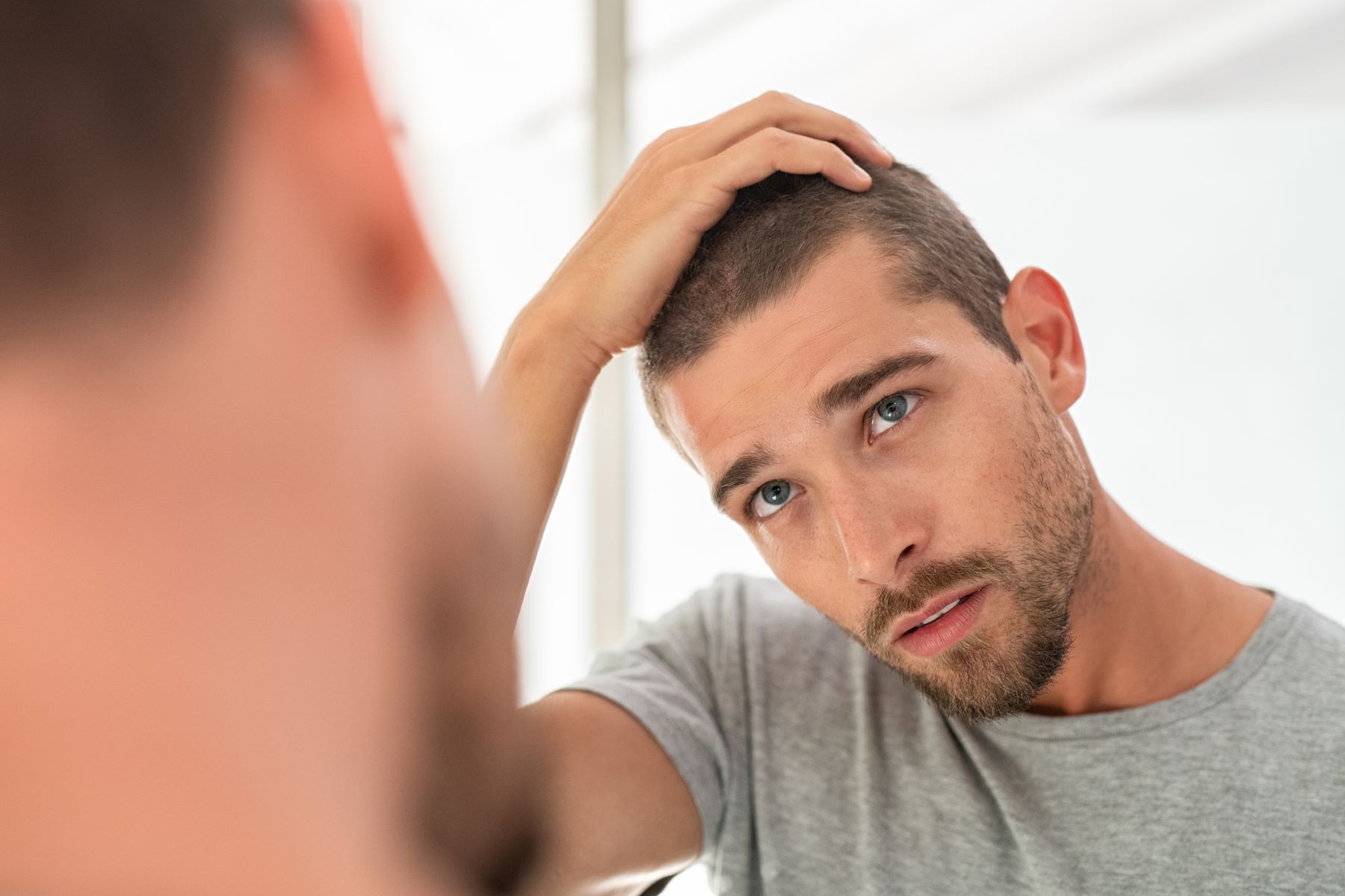 Man checking if his lost hair is growing back