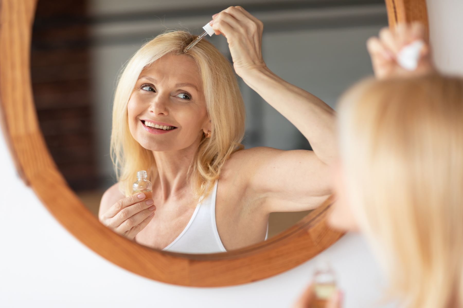 Woman applying hyaluronic acid to her scalp