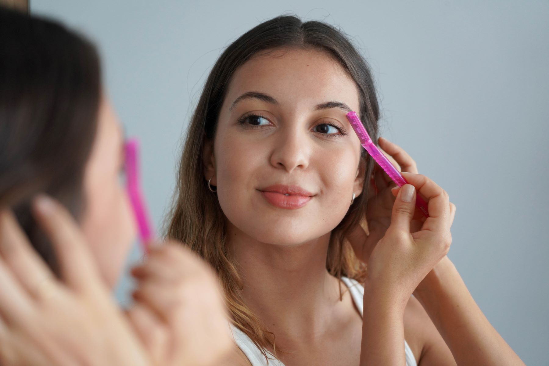 Woman shaving her eyebrows