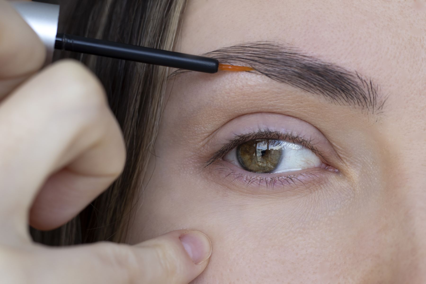 Woman using eyebrow growth serum