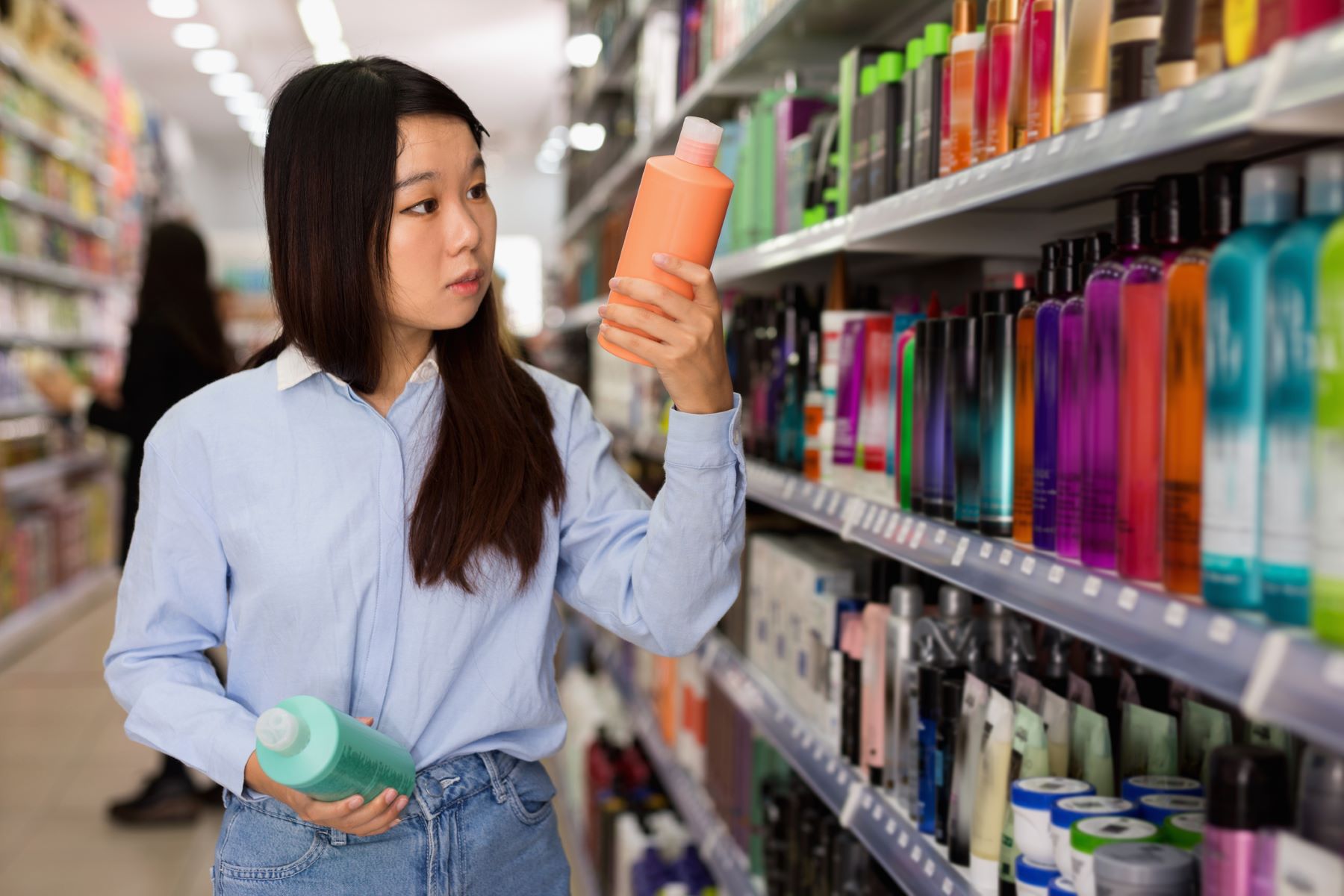 woman choosing hair and scalp detox shampoo