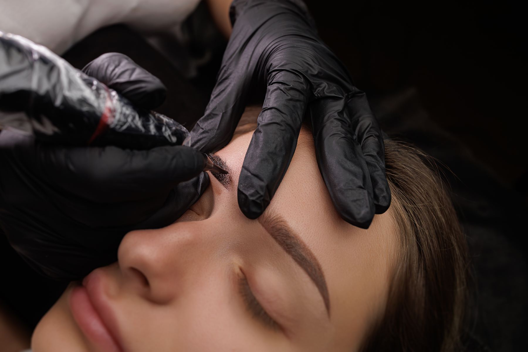 Woman getting an eyebrow tattoo