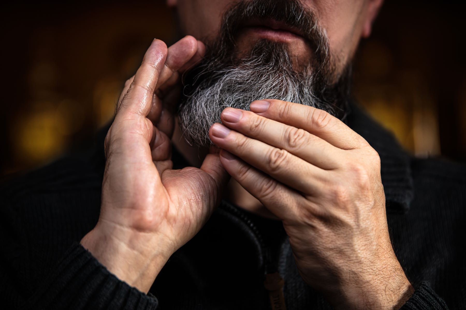 Man applying oil to his beard