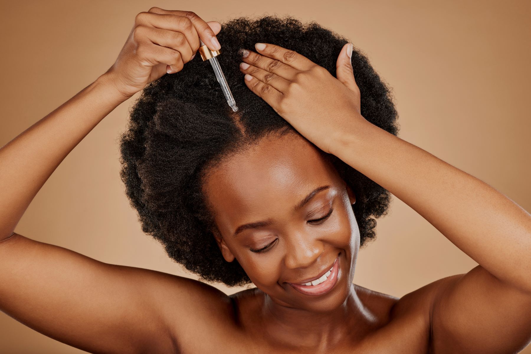 Woman using batana oil on her hair