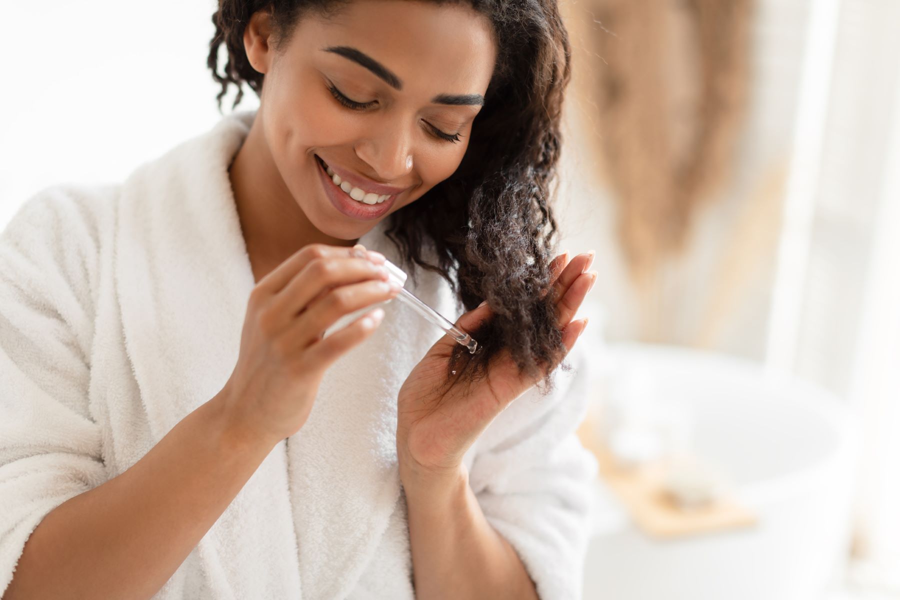 Woman using hair oil to prevent dead hair