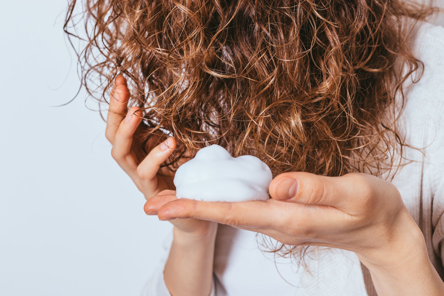 Woman styling her curly hair