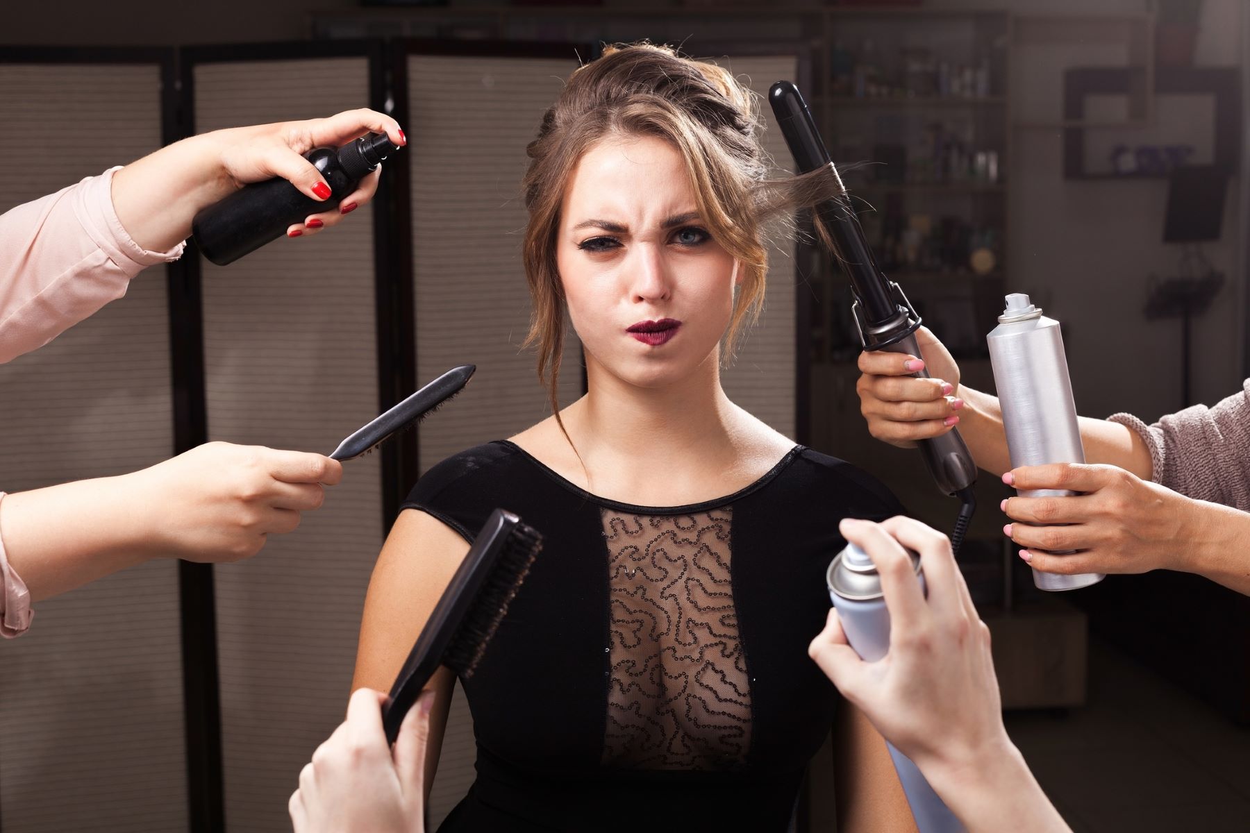 Women surrounded by styling products that cause dry hair