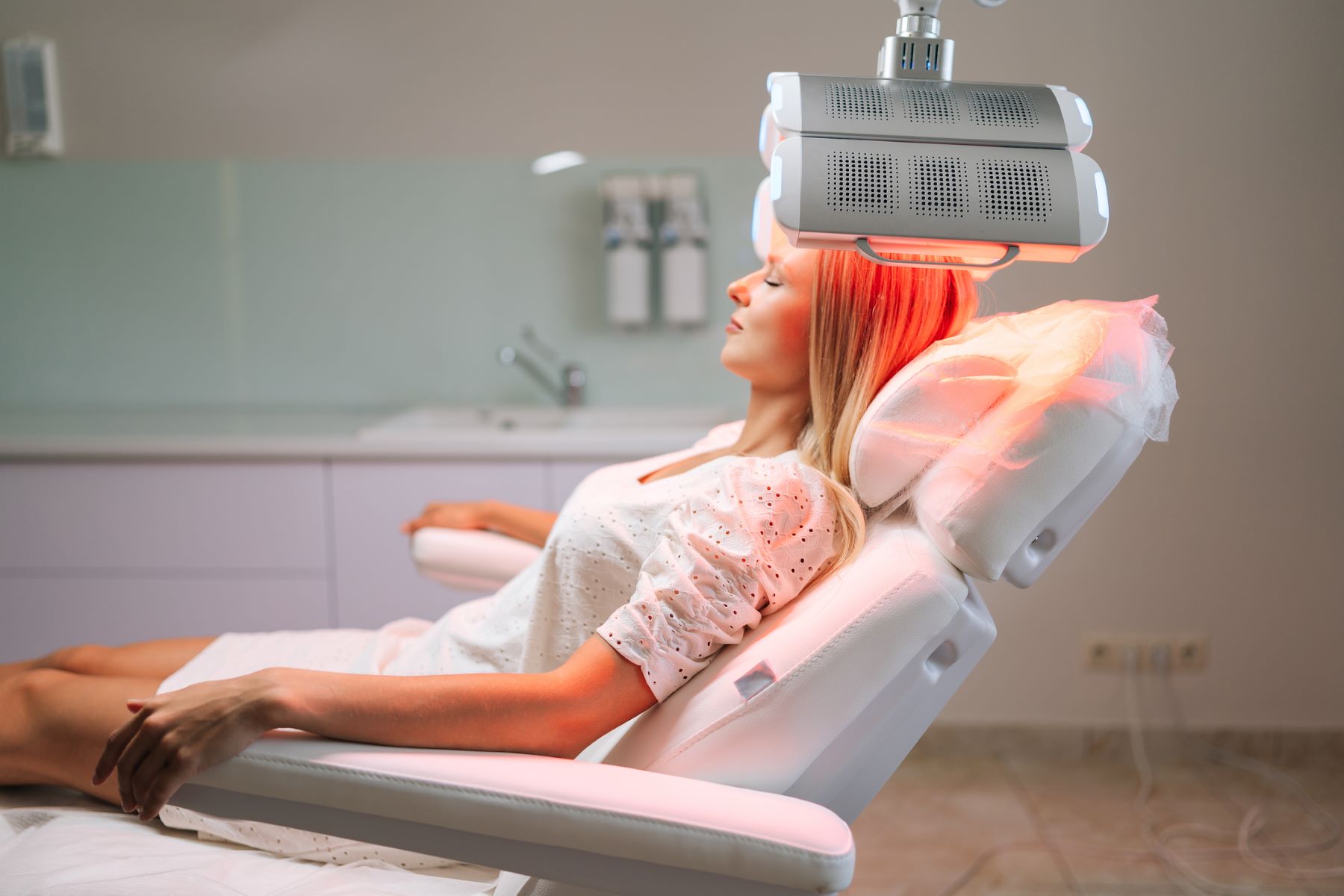 Woman getting red light therapy for hair