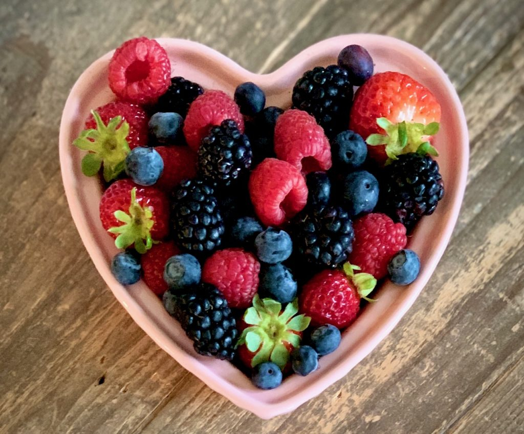 raspberries, blueberries, and strawberries in a bowl