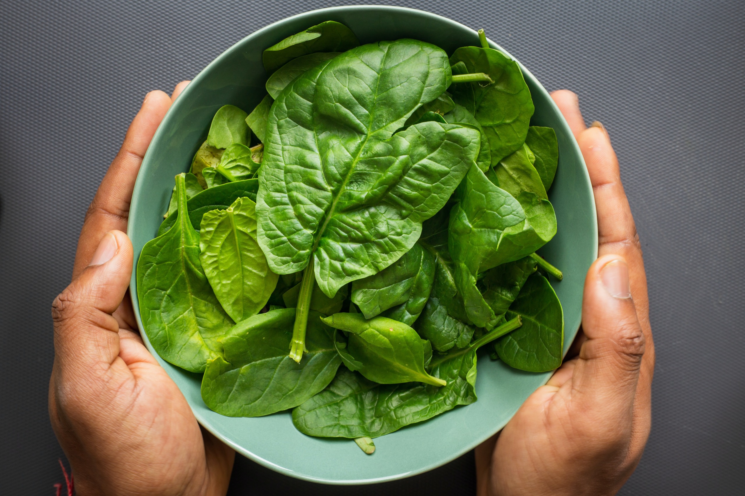 a bowl of fresh raw spinach leaves