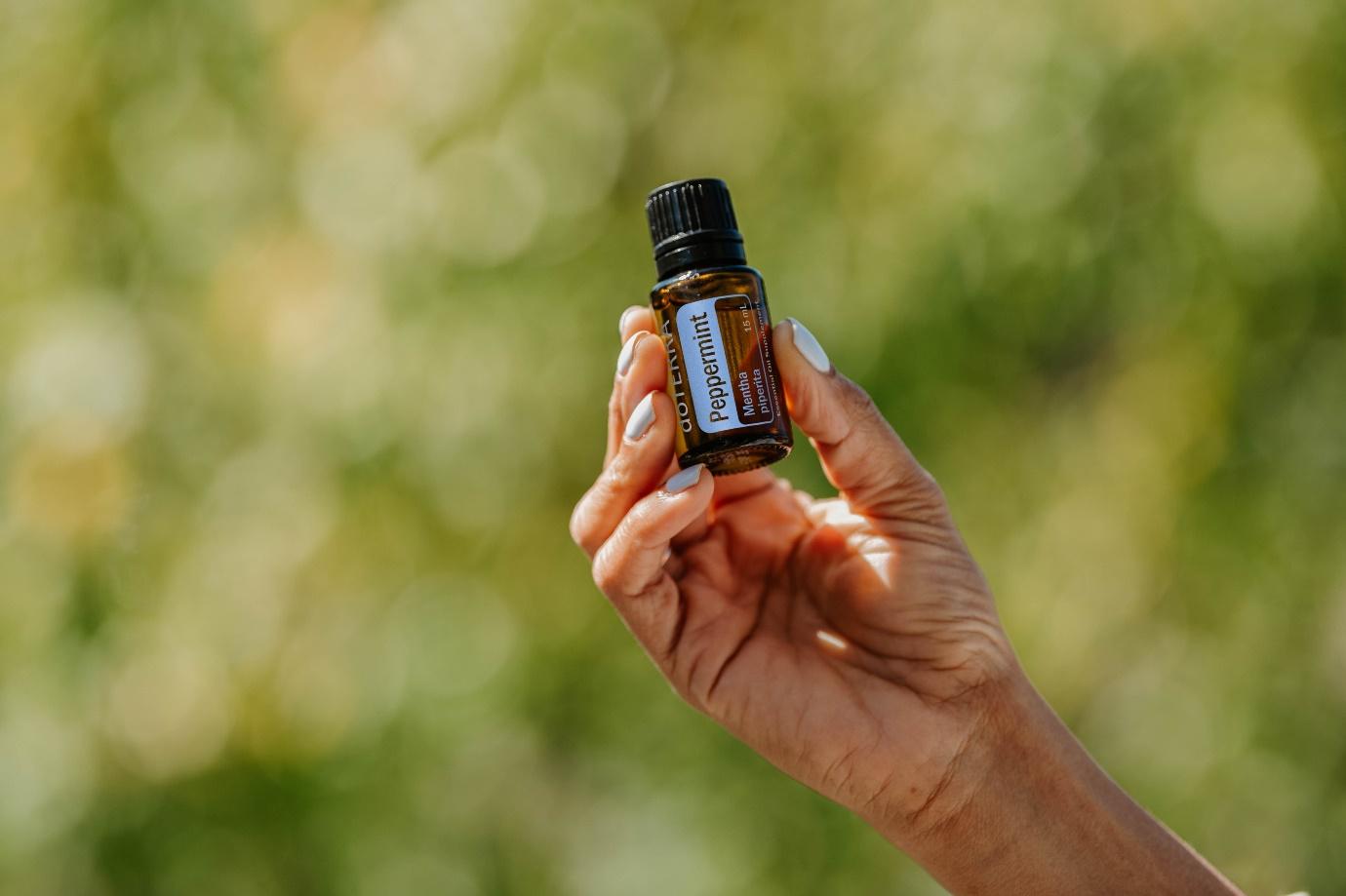hand holding a vial of peppermint oil